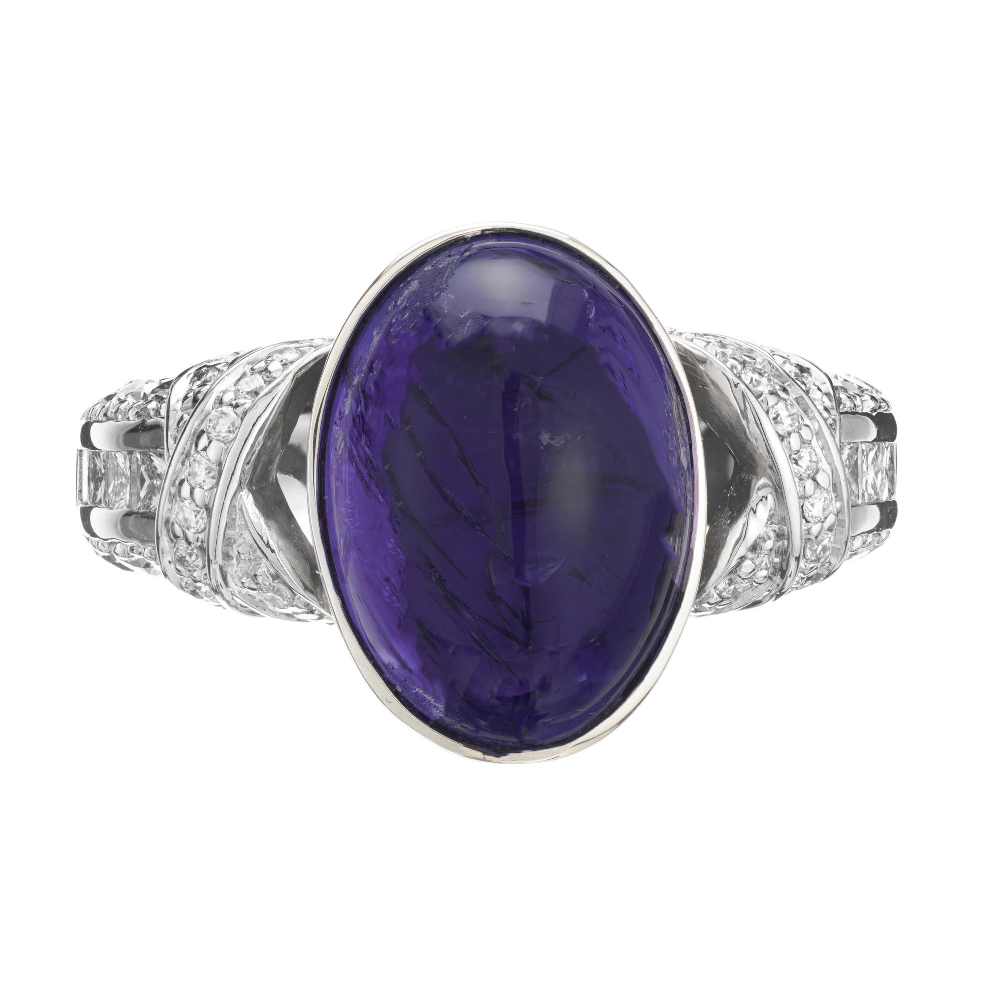 1970's Tanzanite and diamond ring. 9.88 Carat oval cabochon bezel set Tanzanite center stone. Mounted in a 14k white gold X style setting with 8 princess cut accent diamonds along the shank and 46 round cut diamonds also along the shank and X design