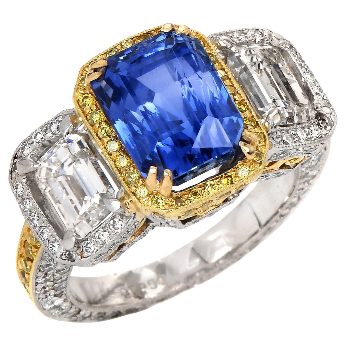 This stunning three-stone diamond ring from the 21st Century is crafted in solid platinum and 18k gold. Showcasing in the center with one Octagonal Modified brilliant step cut Ceylon no-heat Royal blue Sapphire weighing approx. 5.06 carats,
