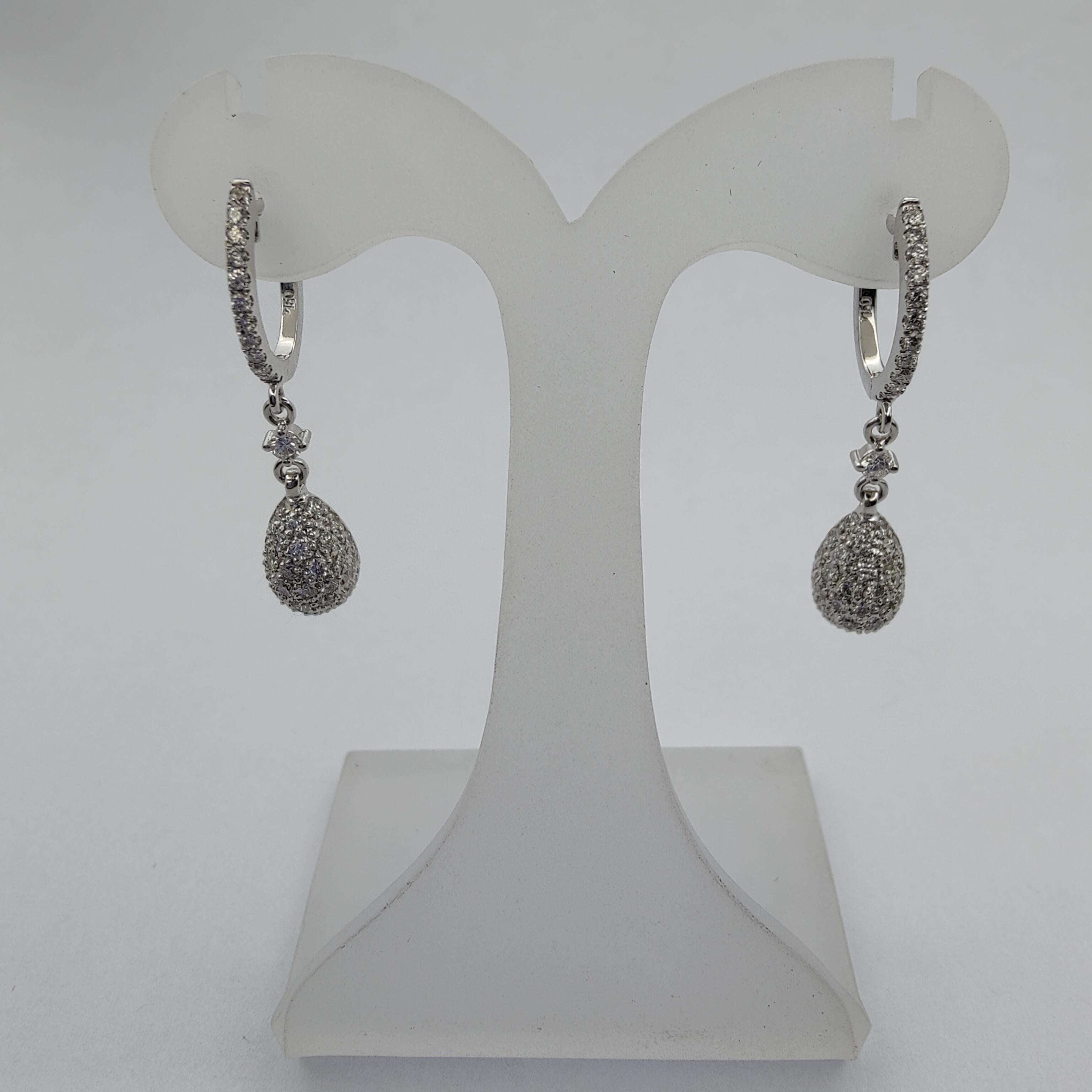 These stunning 0.99 carat diamond nugget drop earrings are the perfect accessory for any special occasion. Inspired by gold nuggets, each of these earrings is roughly oval and encrusted with a cluster of melee diamonds. The upper dangle is set with