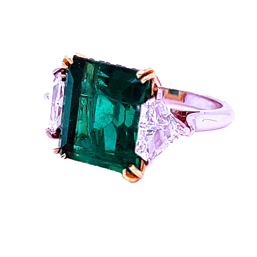 Beautiful hand fabricated platinum & 18k gold ring with AGL certified 9.91 carat emerald and two shield cut diamonds weighing 1.31 carats.