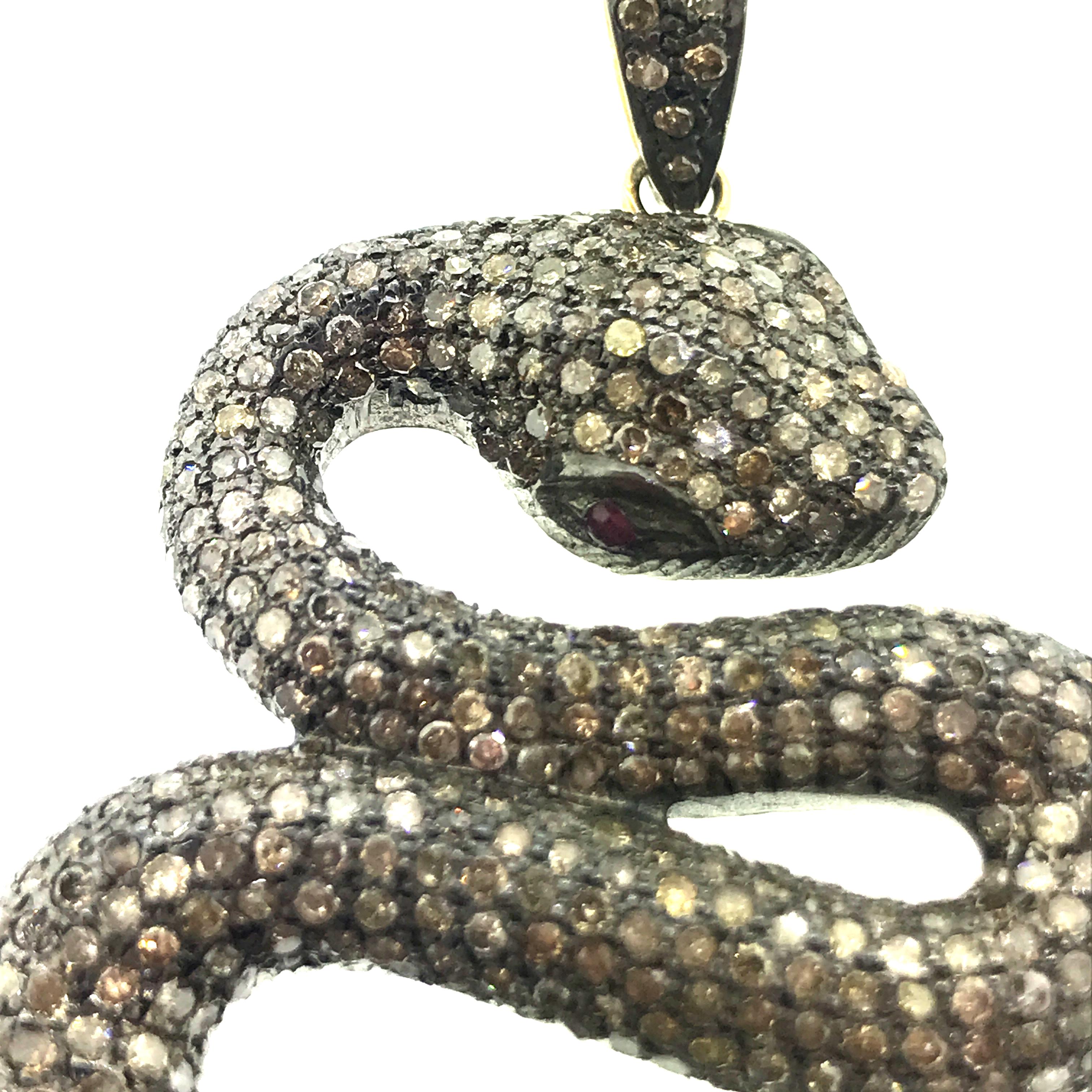 9.93 ct of Pave Champagne Diamonds with 0.08 ct of Ruby Eyes Snake set in Oxidized Sterling Silver with Back of bail in 14KT Gold. The snake 3.5 Inch Long along with the bail (bail is attached to the snake body with a 14KT Gold jump ring). 
Stones :