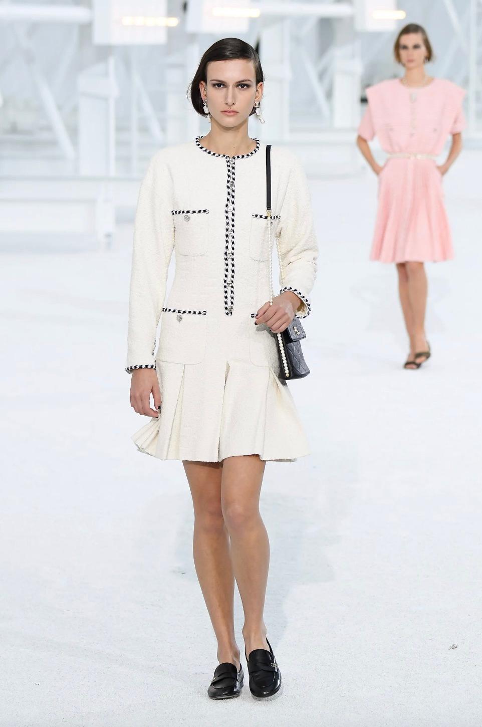 Elevate your wardrobe with this classic white tweed dress from Chanel Spring/Summer 2021 collection. Seen on Charlotte Casiraghi during Interview with Chanel and showcased in leading fashion magazines. Crafted with precision, this mini dress boasts