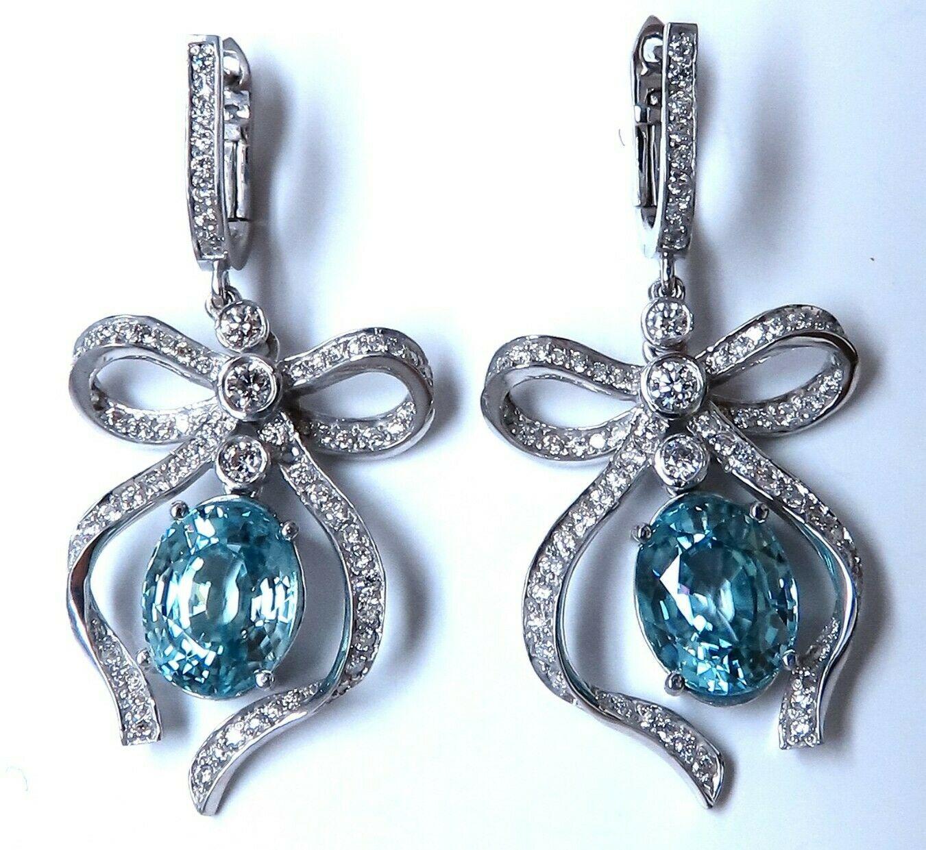 Blue zircon Ribbon dangle earrings.

9.95ct Natural Oval Blue Zircons.

9.7 x 7.6mm

Vivid indigo blue clean clarity and transparent

1.10 carat natural round billion diamonds

G color vs2 clarity

14 karat white gold 11 g

Earrings 1.5 in Long &