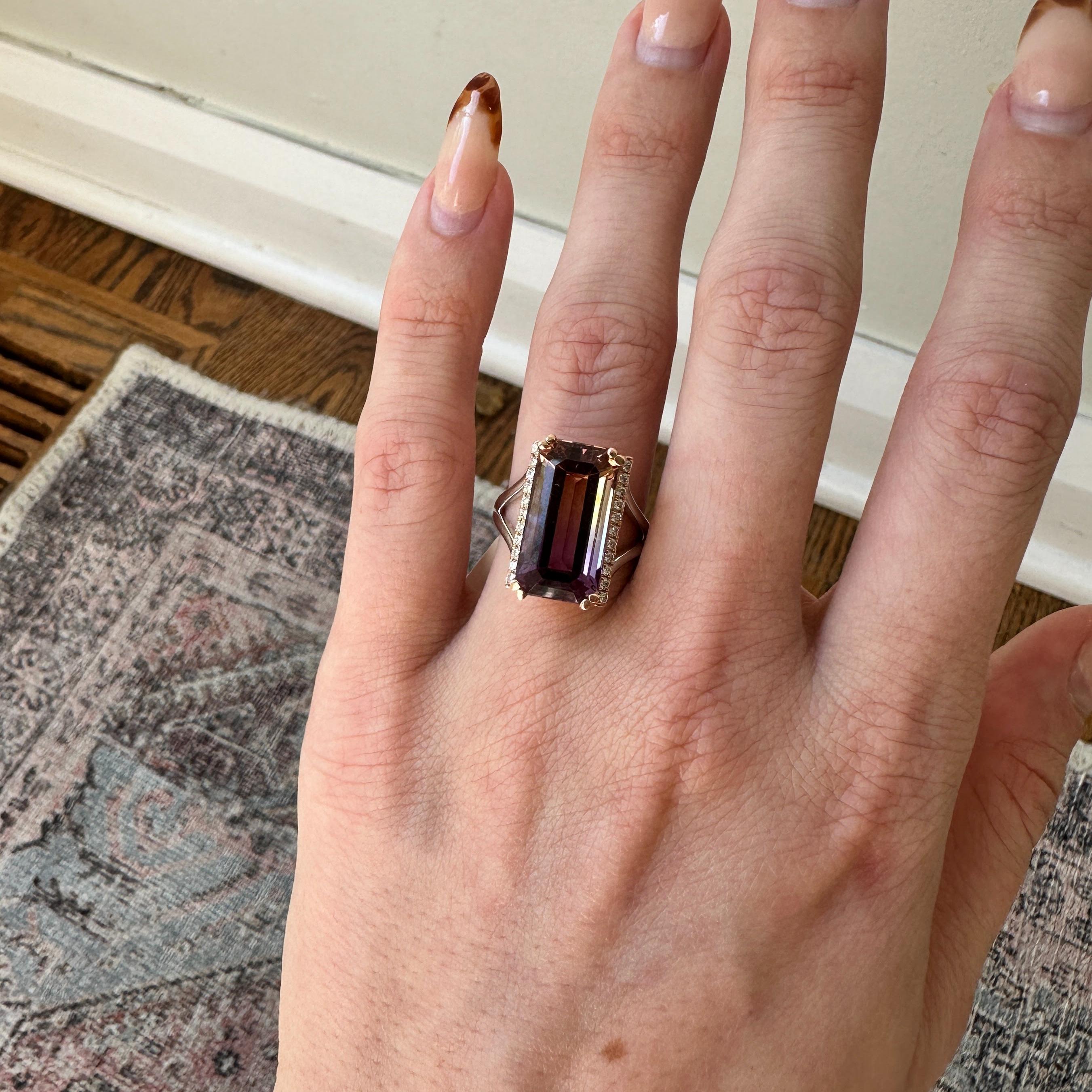 Elegant and captivating, this statement ring showcases a stunning 9.02 carat Brazilian Ametrine gemstone with a mesmerizing gradient of purple and yellow hues. The center stone is framed by natural earth mined diamonds on either side set in solid