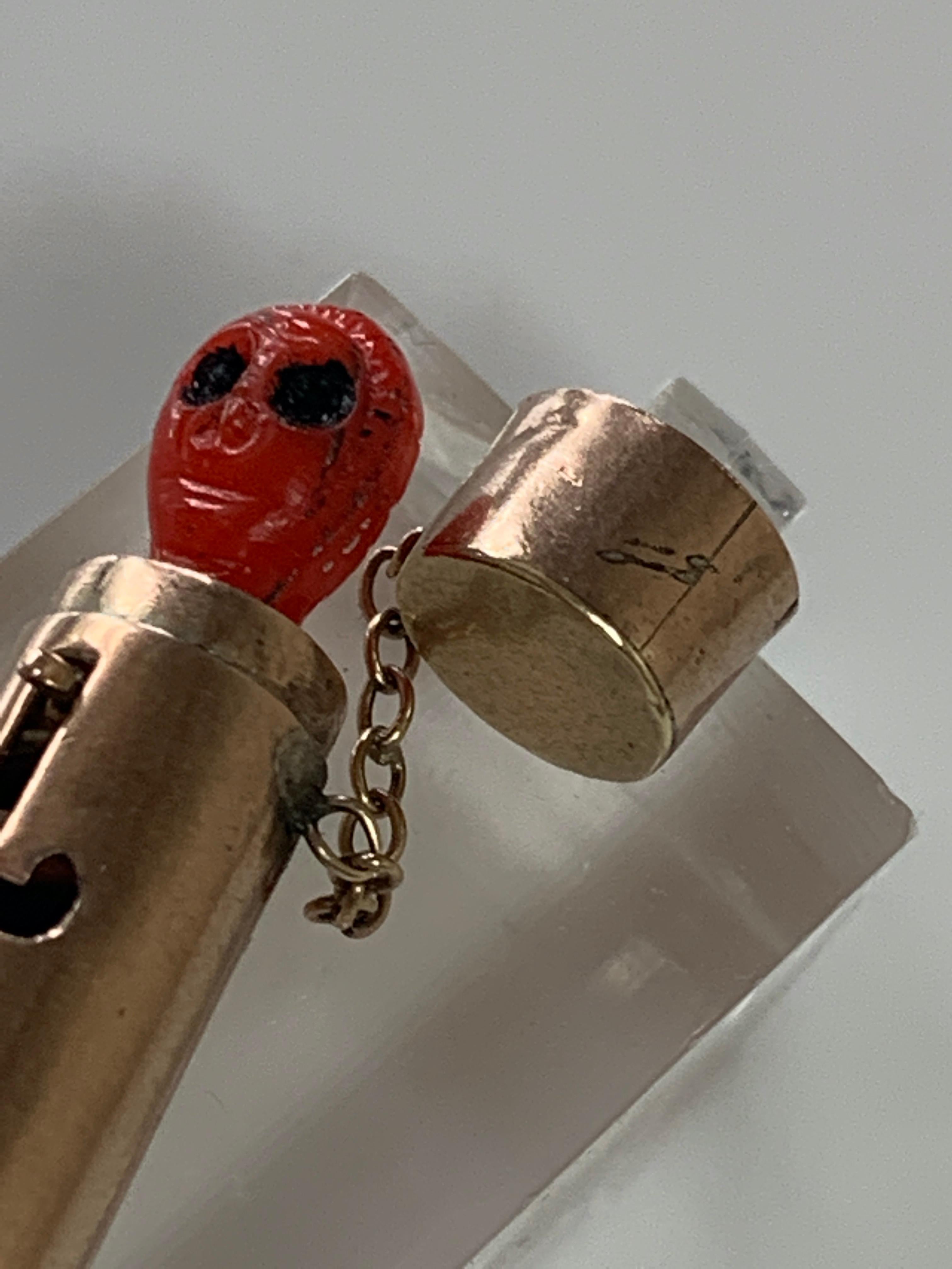 Rare 9ct 375 Gold Canister with pop up mechanism 
Era 1950s
Chain attached to lid
Push slightly down on the alien head then move across the release handle
and it springs up.
Alien head appears to be Bakelite ? - early plastic/acrylic
all over item