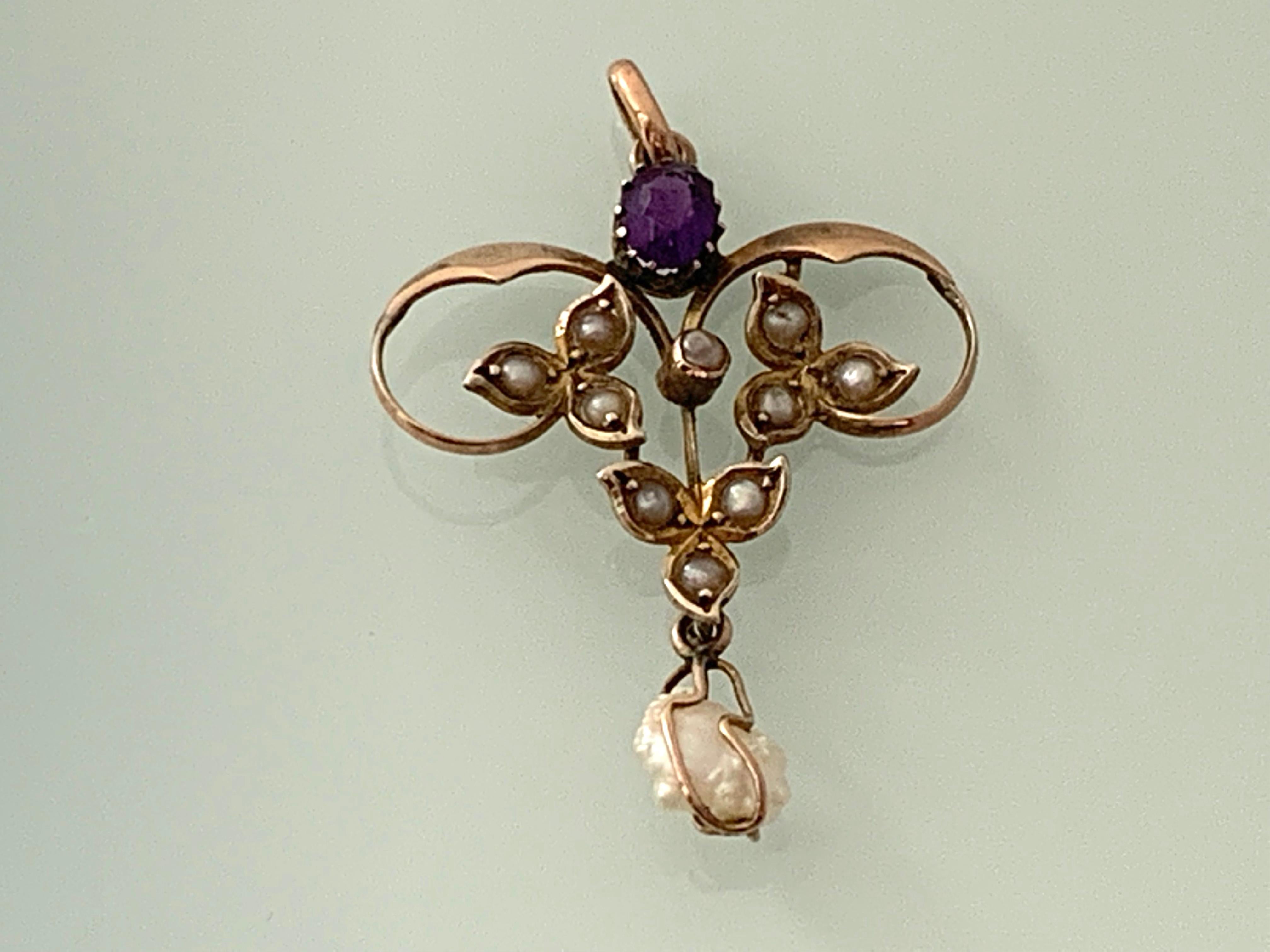 9ct Gold Antique Victorian Pendant 
which is adorned with  ten seed pearls 
and a finale blister pearl thats swings encaged 
topped by a purple oval gemstone.
Stamped 9ct top right side on reverse.
Bail is closed .
Pendant is handmade late 19