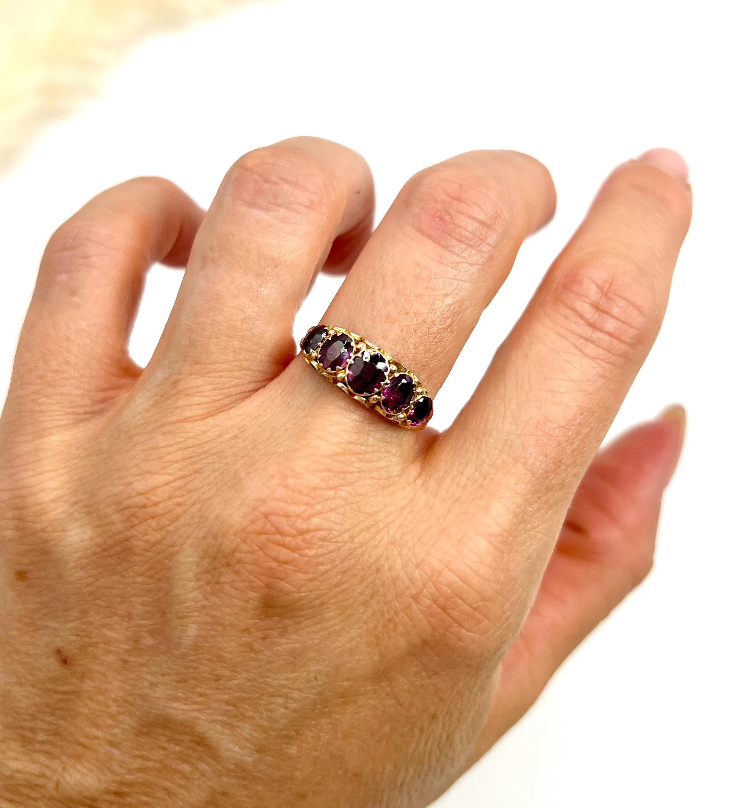 Anillo antiguo de granate almandino 

Oro amarillo de 9 ct 

Con matasellos de Birmingham 1857

Este asombroso anillo victoriano de oro de 9 ct con cinco piedras muestra un exquisito diseño que capta maravillosamente la elegancia de la época. El