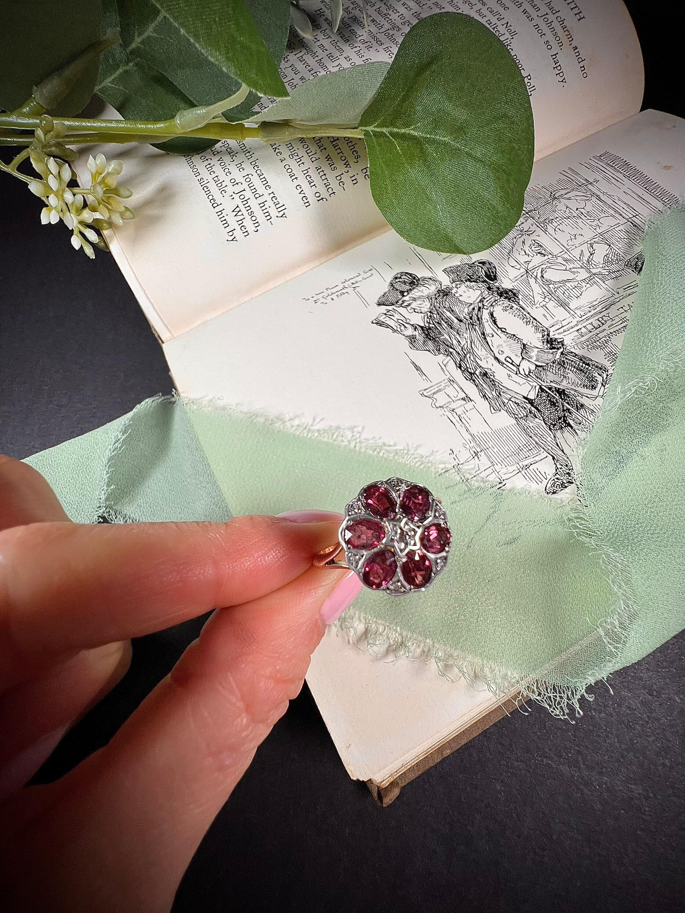 Antique Garnet Daisy Ring

9ct Gold Stamped

Circa 1920’s

Makers Mark W N 

Beautiful, 1920’s daisy ring. Set with gorgeous, faceted garnet petals & tiny little rose cut diamonds, with a star set diamond to the centre. Mounted on pretty split