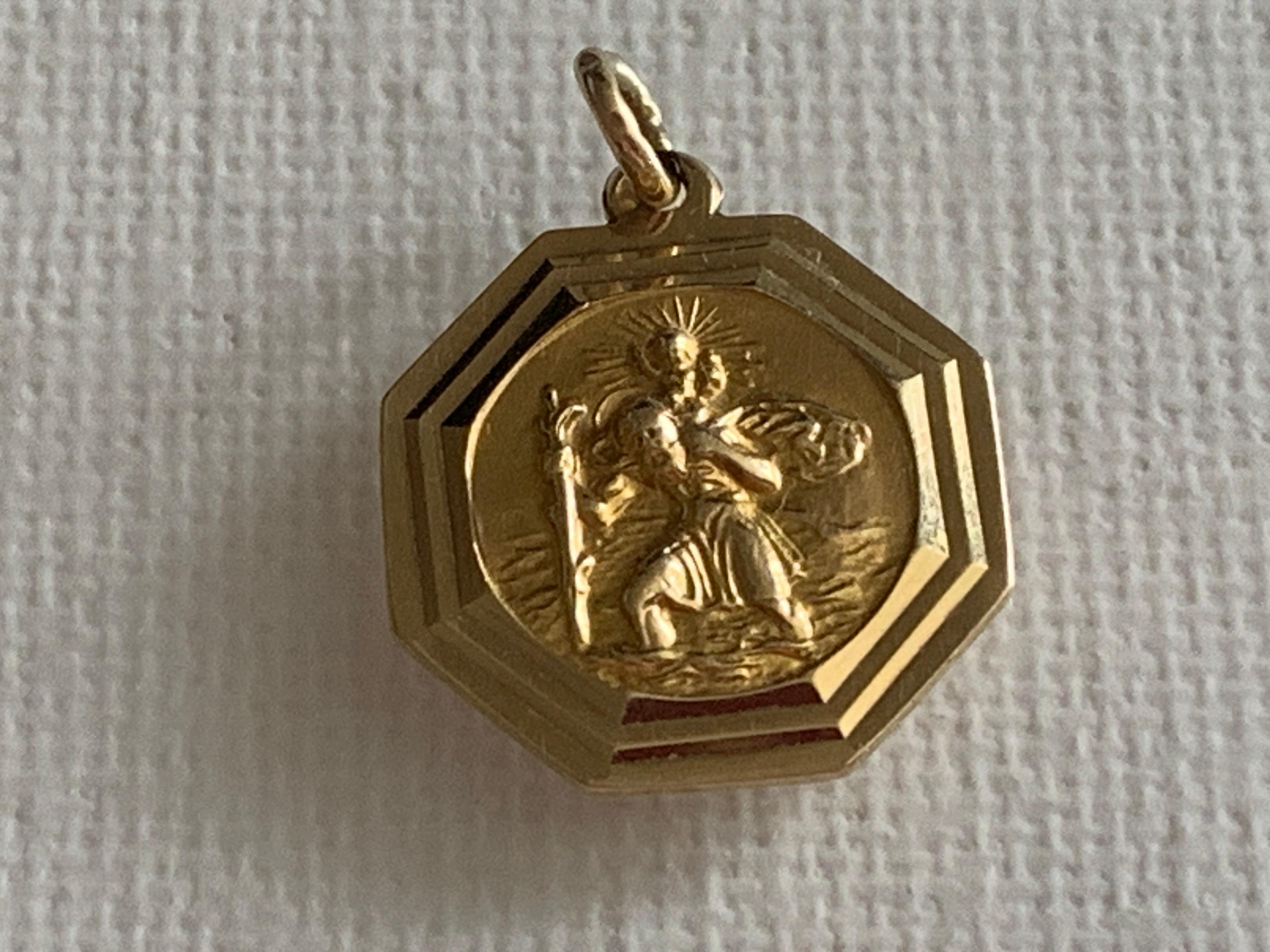 9ct 375 Gold St.Christopher 
Hexagon Shaped Pendant
with bezelled edge
by Danish Goldsmith Georg Jensen
Full British Hallmarks
Dated 1965 by London Assay Offices
Size - Diameter - 17 mm ( millimeter)
Weight 2.7 grams
