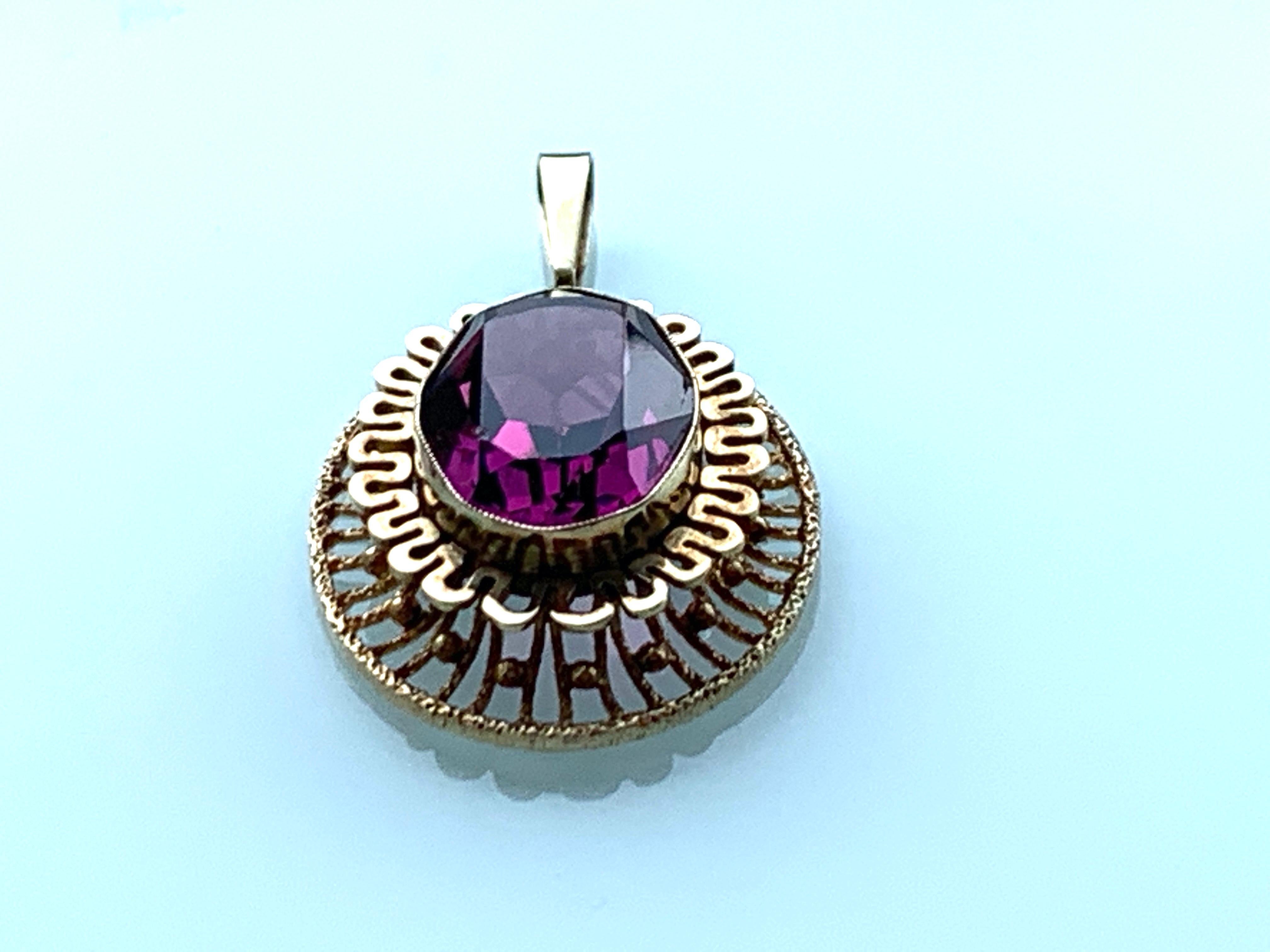 9ct Gold Large Pendant 
with unknown Purple Faceted Gemstone
Beautiful Statement piece of jewellery.
Era 1970s
Makers Stamps A&D
