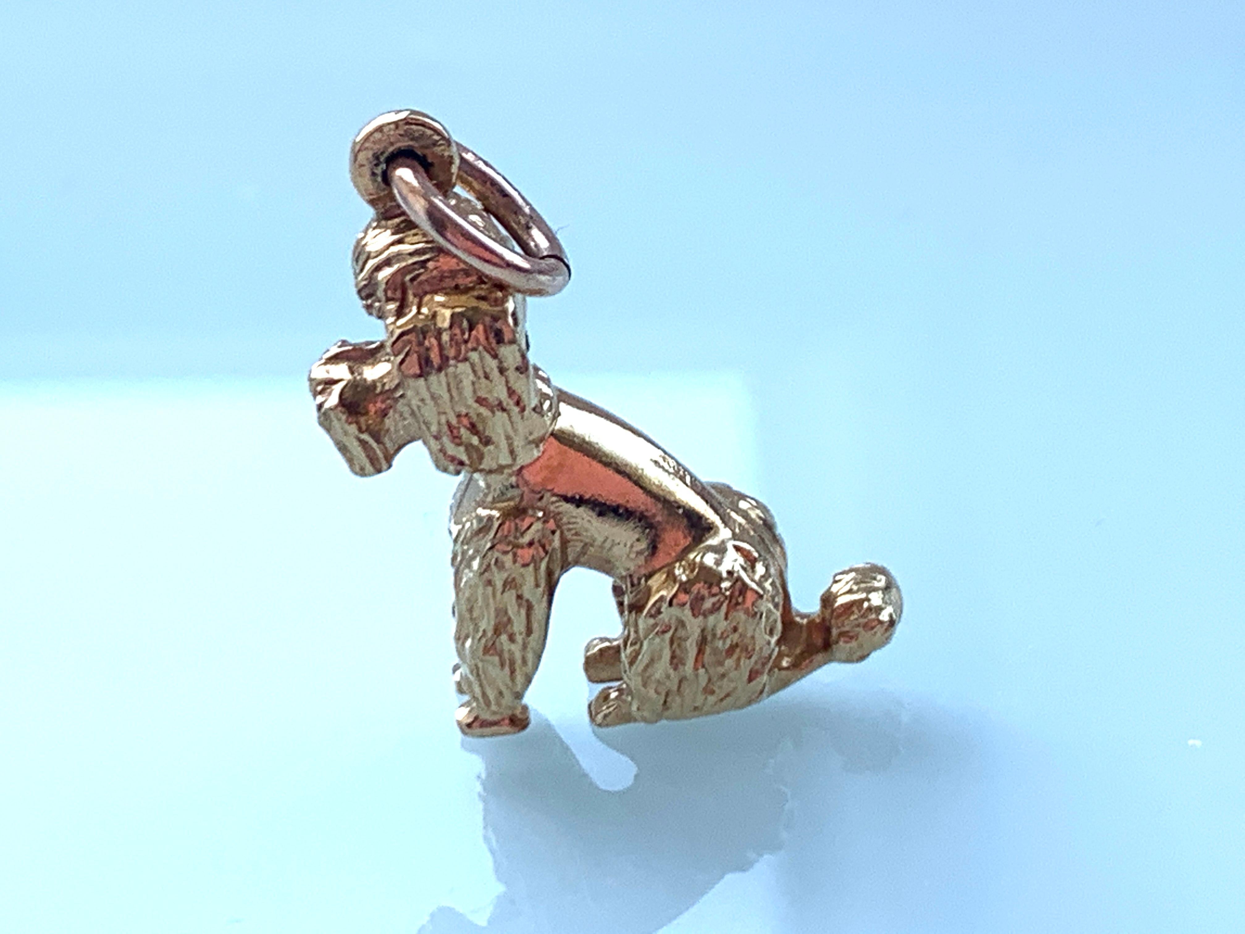 9ct Gold Poodle 
by Famous Danish Goldsmiths Georg Jensen
With genuine ruby eyes
Solid Charm not hollow
Full British Hallmarks present
9 375 London assay mark date letter R
Stamped GJ Ld