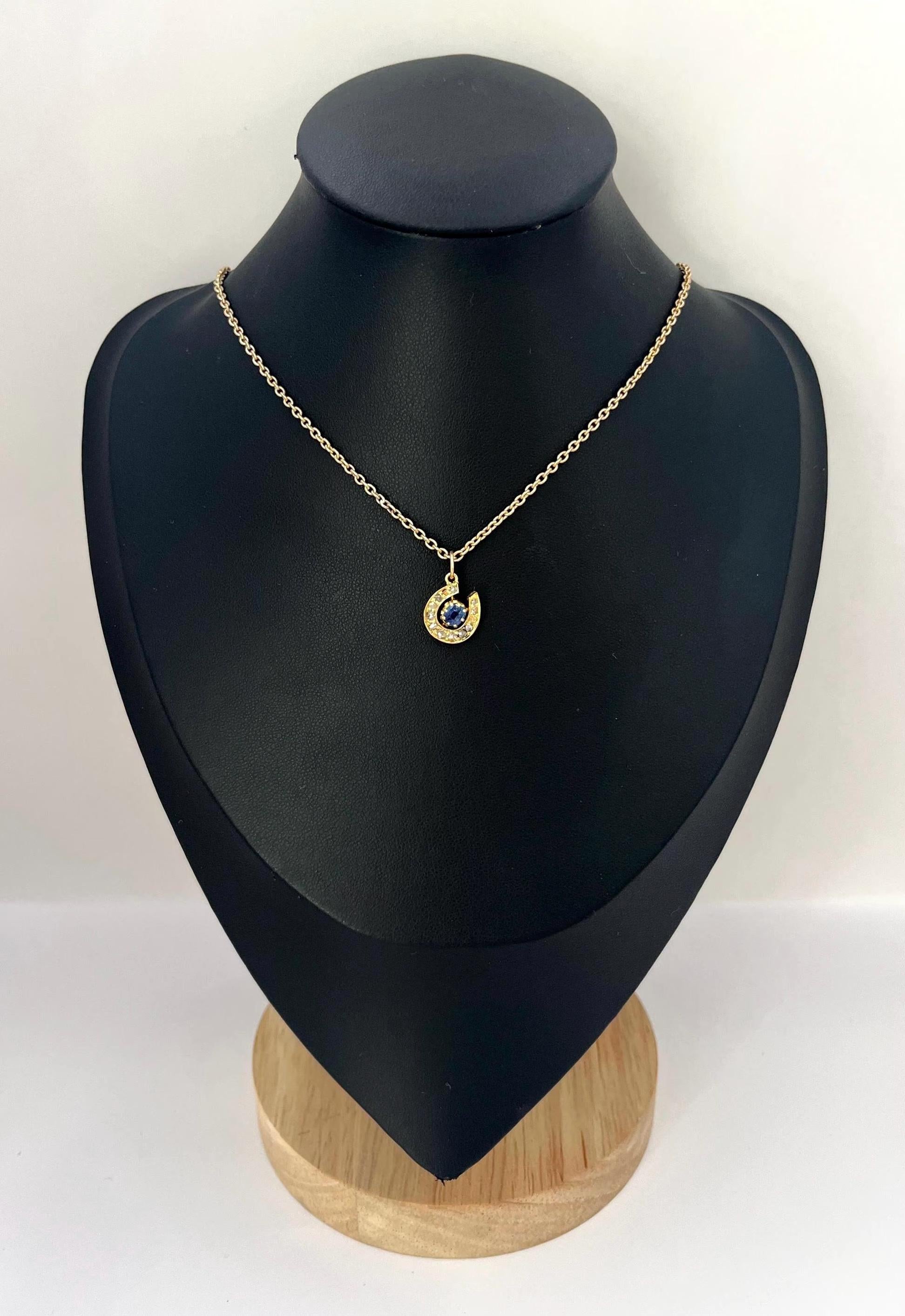 Collier ancien en fer à cheval 

Or 9 carats

Circa 1880

Pendentif victorien en forme de fer à cheval en or jaune 9ct, serti de treize diamants taillés en rose et d'un saphir central taillé en rond pesant environ 0,18ct. 
Les diamants sont disposés