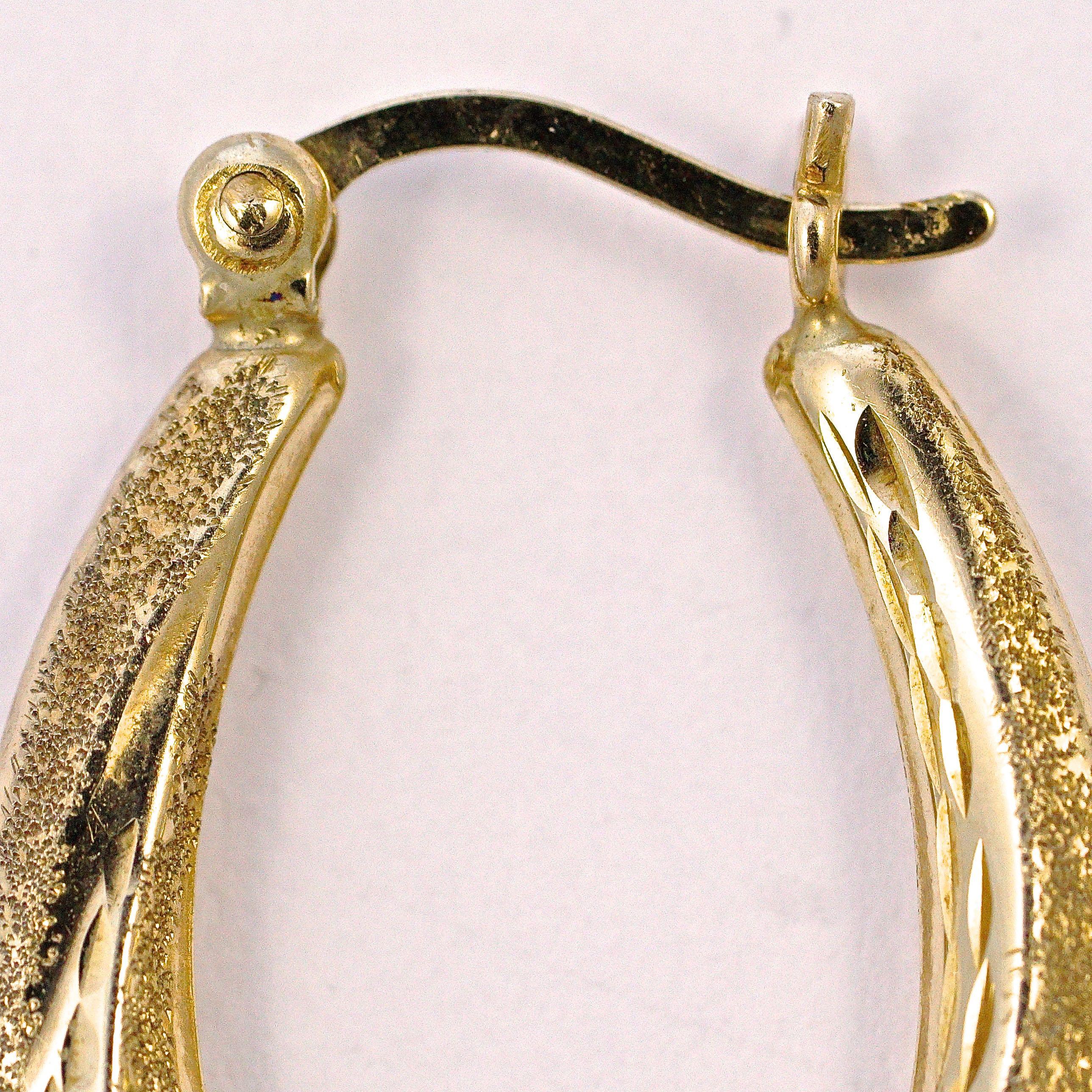 9ct gold earrings featuring wonderful textured and diamond cut oval hoops. Measuring length 2.45cm / .96 inch by width 1.65cm / .65 inch. The earrings are in very good condition.

This is a beautiful pair of vintage hoop earrings, perfect for