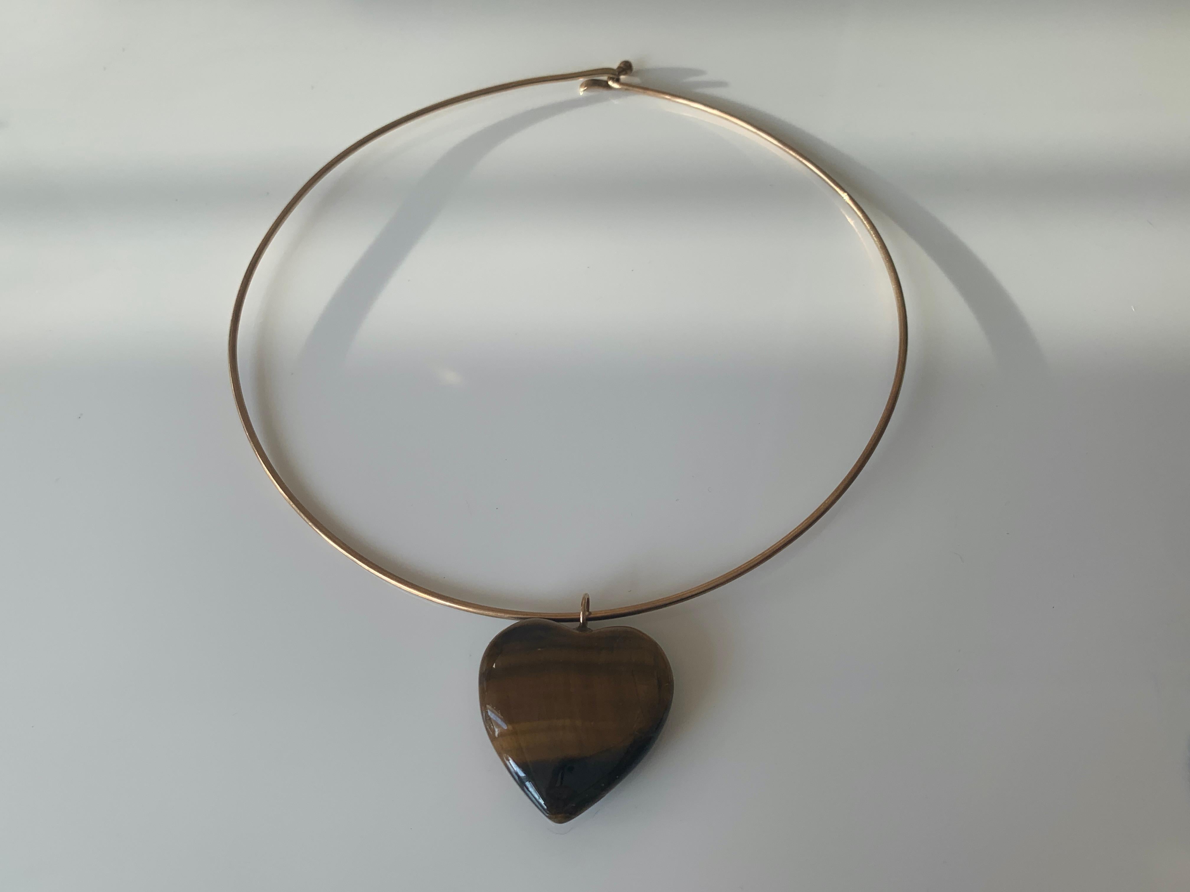 Simplistic 1980's 
9ct 375 Gold  Solid Choker 
Size 15 Inch circumference
weight of choker is 8 grammes
 tigers eye stone heart pendant
weight of pendant alone is 12 grammes
choker is stamped 9ct .