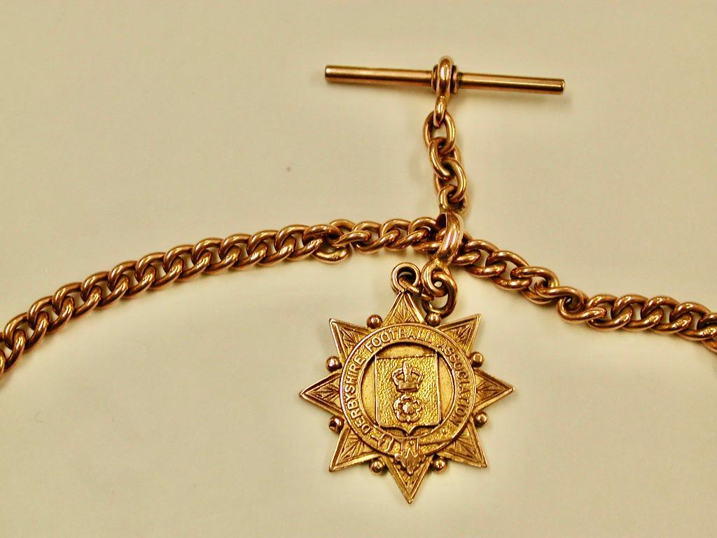 9ct Gold Watch Albert,Dated Circa 1900
Made with a sturdy curb link, and has 9ct stamped on every link and the bar and bulldog clips.
The attached 9ct gold football medal is dated 1906, made in Birmingham.
We presume the chain is of the same date.