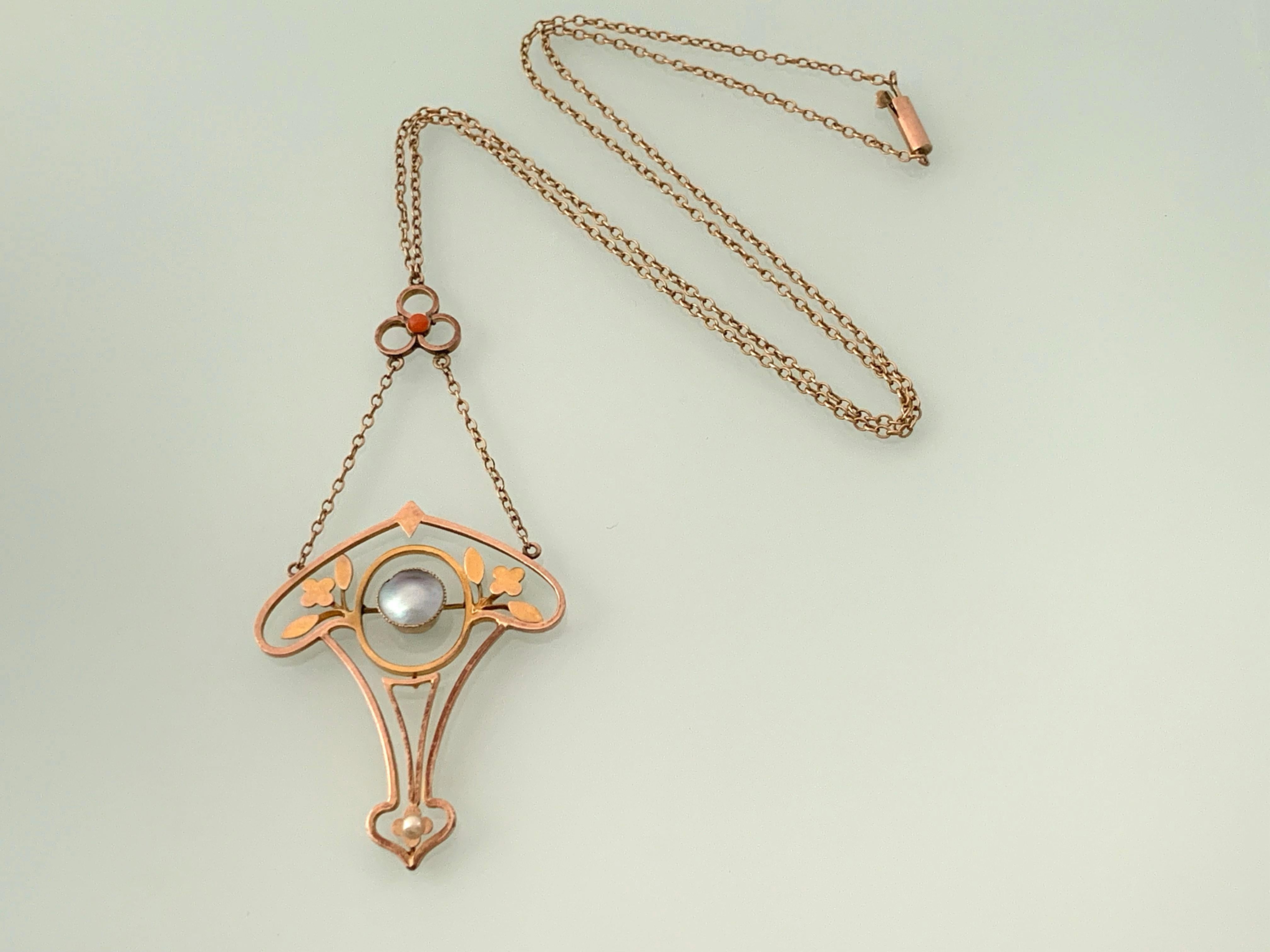 9ct Rose Gold Victorian Antique Necklace
with central Half Pearl  topped with a small coral cabochon & finalled with a seed pearl
The central Pearl has a blue Hue
fastened with a Barrel clasp .
The chain is approx 1mm thickness
and without the drop