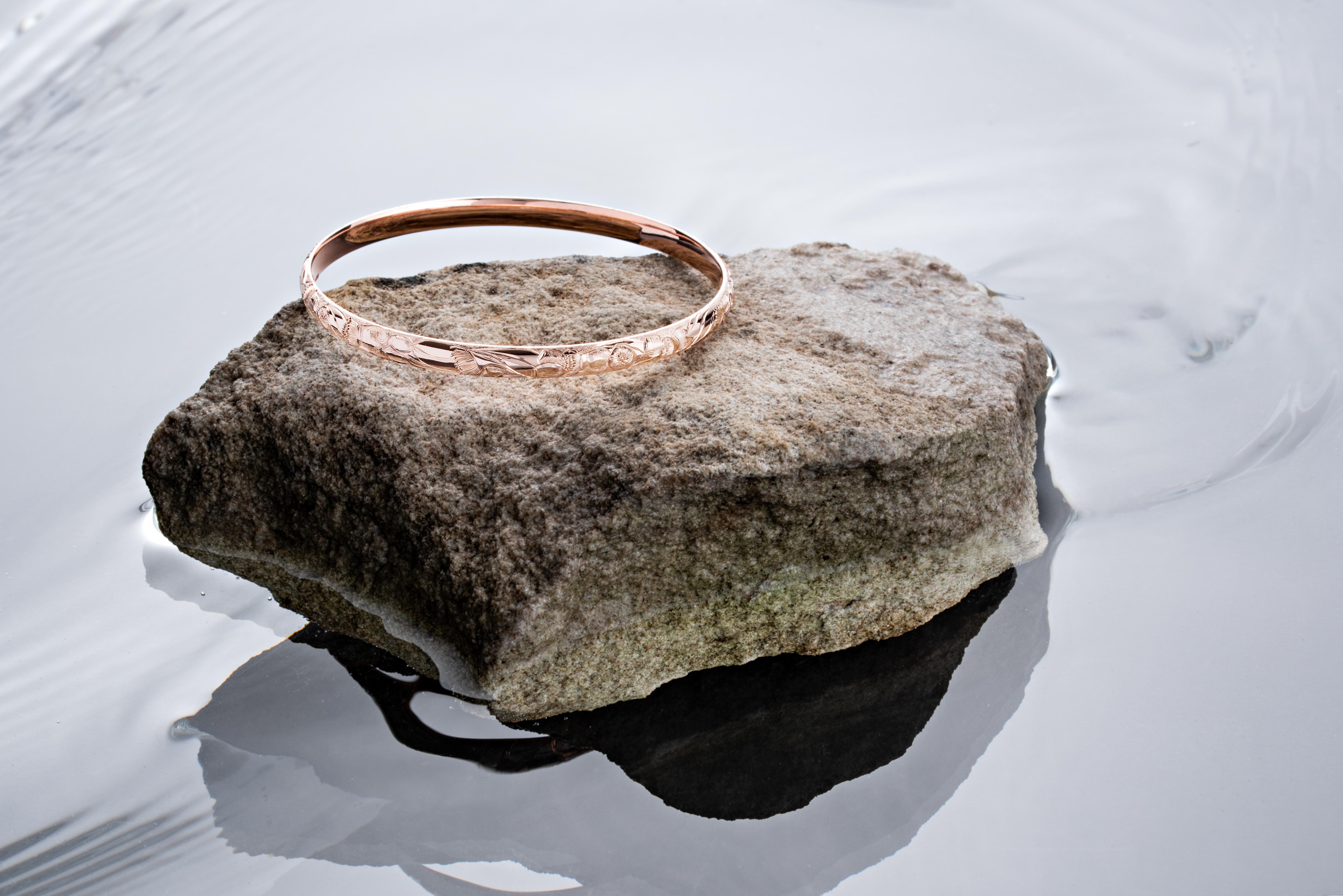 One 9ct. rose gold solid round bangle featuring a uniquely hand- engraved gum nuts pattern.