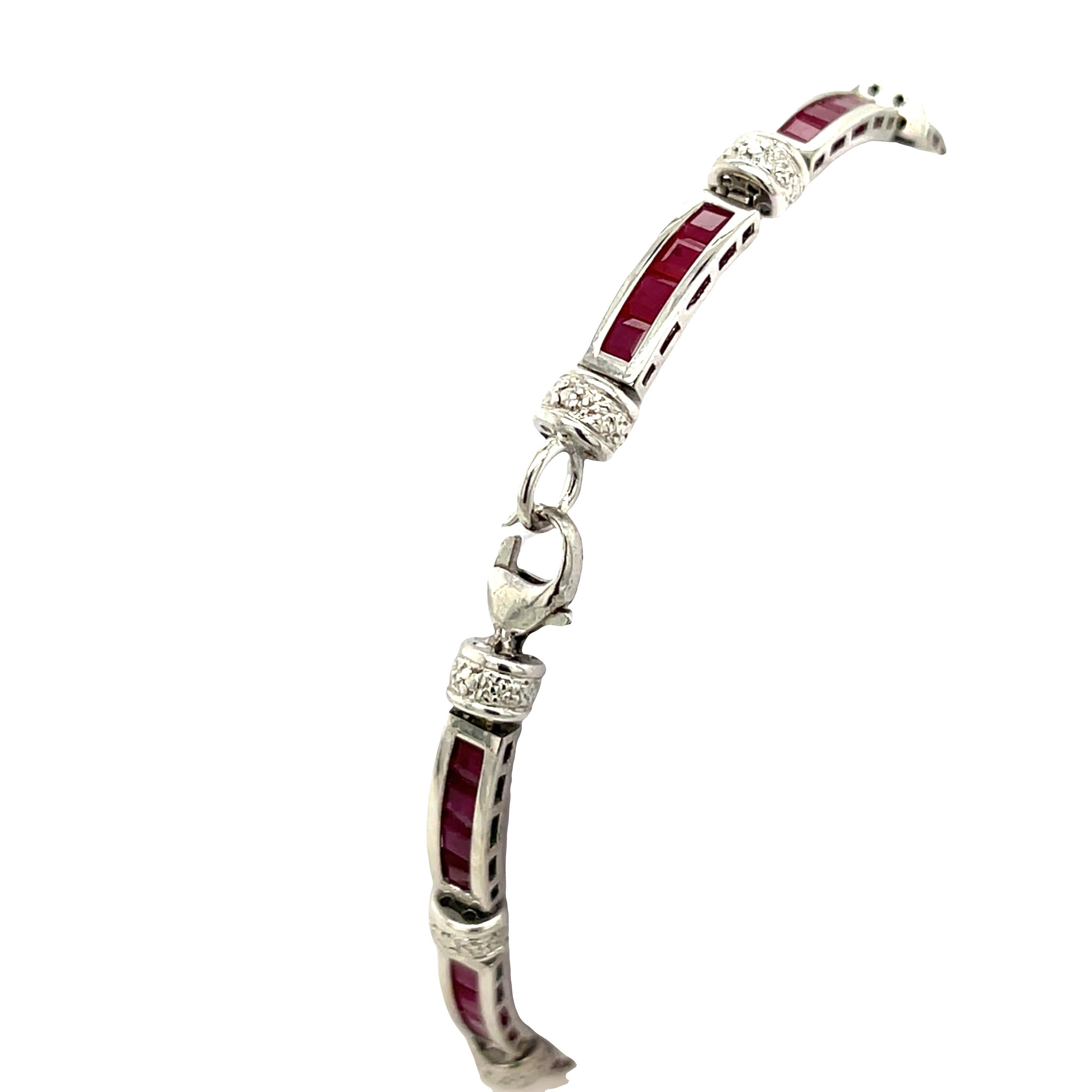 Impresionante expresión de elegancia clásica, esta pulsera está elaborada en oro blanco de 9 ct y engastada con una hilera de vibrantes rubíes naturales de talla cuadrada. 
Cada rubí está expertamente engastado en canal, permitiendo que los