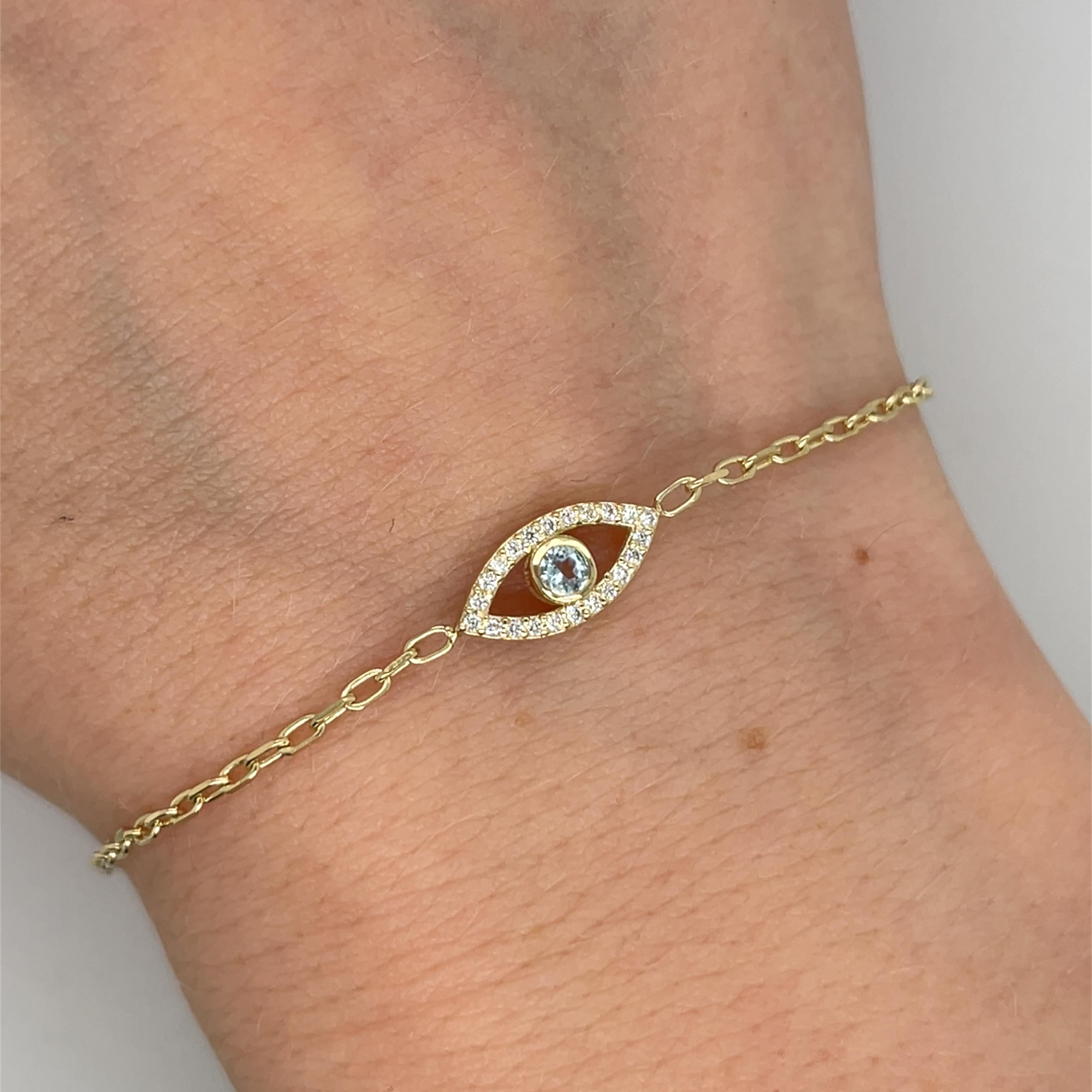 Un étonnant bracelet en or jaune 9ct pour le mauvais œil, 
dont la pièce maîtresse est une aigue-marine d'un bleu profond, la pierre de naissance du mois de mars. L'aigue-marine est encadrée dans un dessin symbolique pour la protection et la bonne