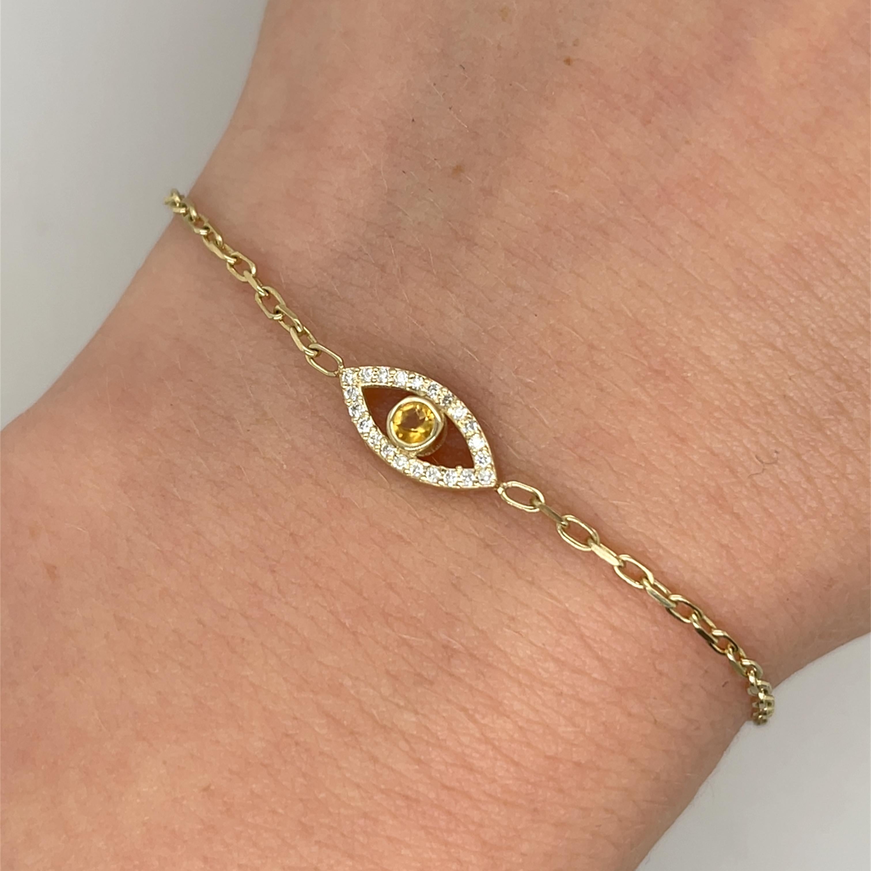 Un étonnant bracelet en or jaune 9ct pour le mauvais œil, 
dont la pièce maîtresse est une citrine orange foncé, la pierre de naissance du mois de novembre. La citrine est encadrée dans un dessin symbolique pour la protection et la bonne