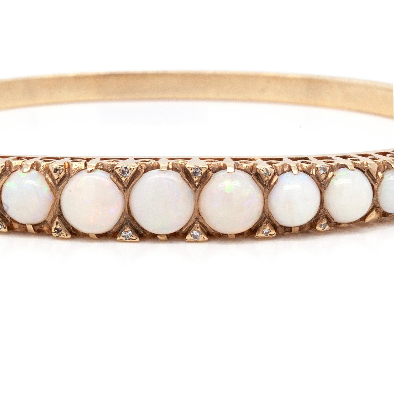 This gorgeous opal and diamond hinge bangle is set with 11 precious round opal cabochons, each with a beautiful play of colour. The opals are interspersed with a total of 12 round cut diamonds, adding brilliance to the piece. The opals are set on
