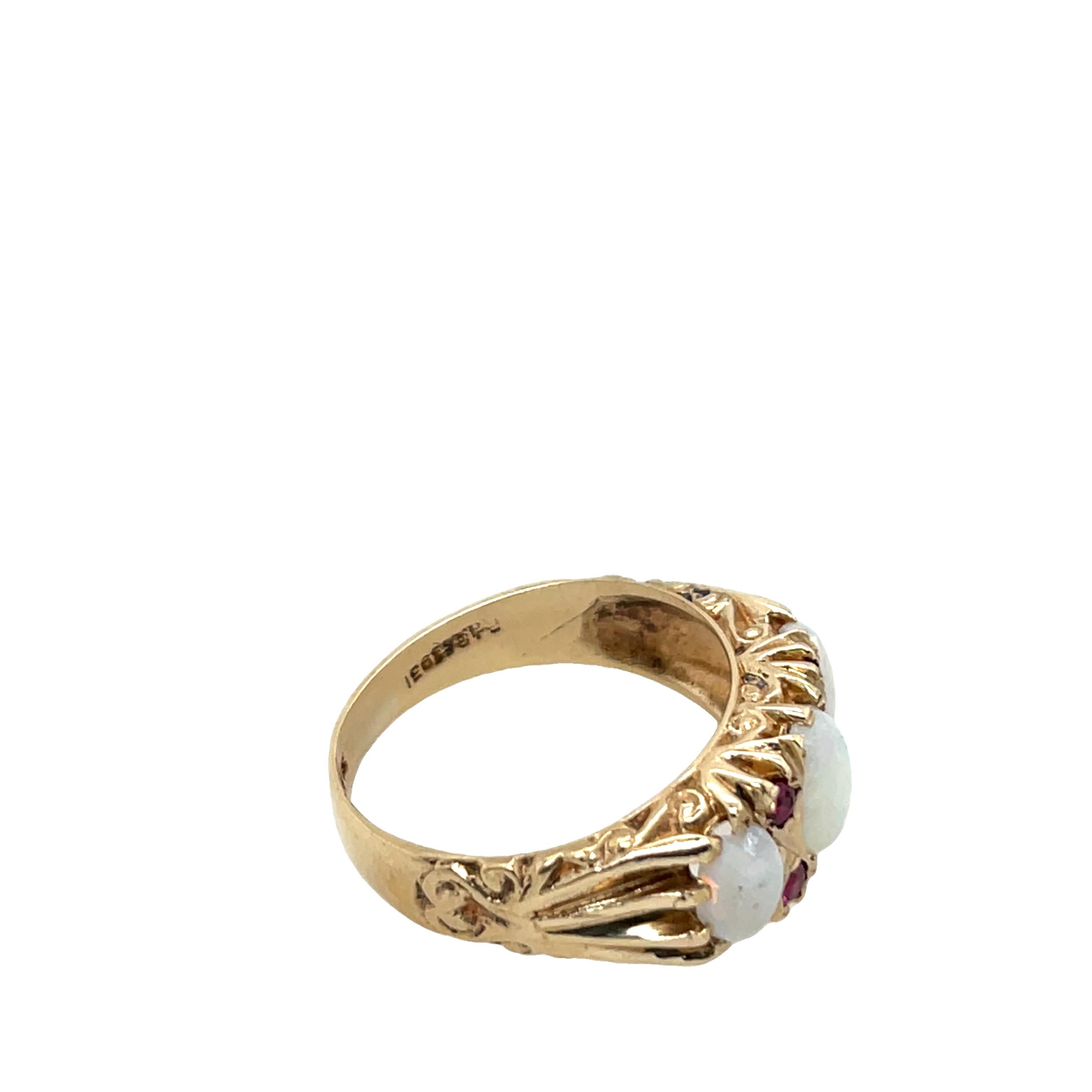 A charming vintage-style ring crafted in 9ct yellow gold, featuring a captivating oval opal at the centre, 
accented by two vibrant rubies. 
The opal displays beautiful play-of-colour, while the rubies add a striking contrast, creating a timeless