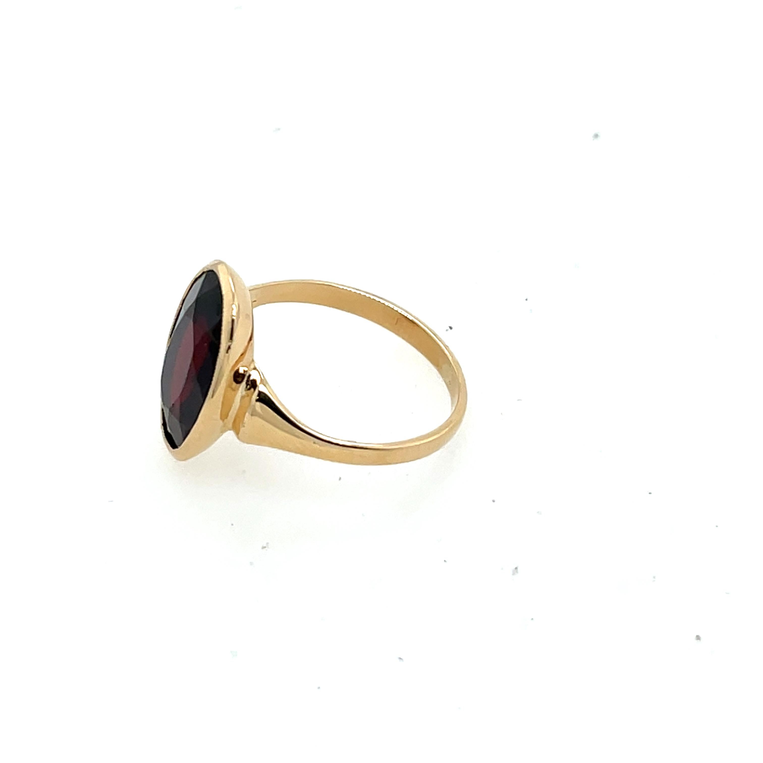 Una pieza atemporal y elegante, este anillo presenta un rico granate de talla ovalada 
engastada en cálido oro amarillo de 9 ct. El tono rojo intenso del granate 
contrasta maravillosamente con la banda de oro, creando un clásico 
y sofisticado.