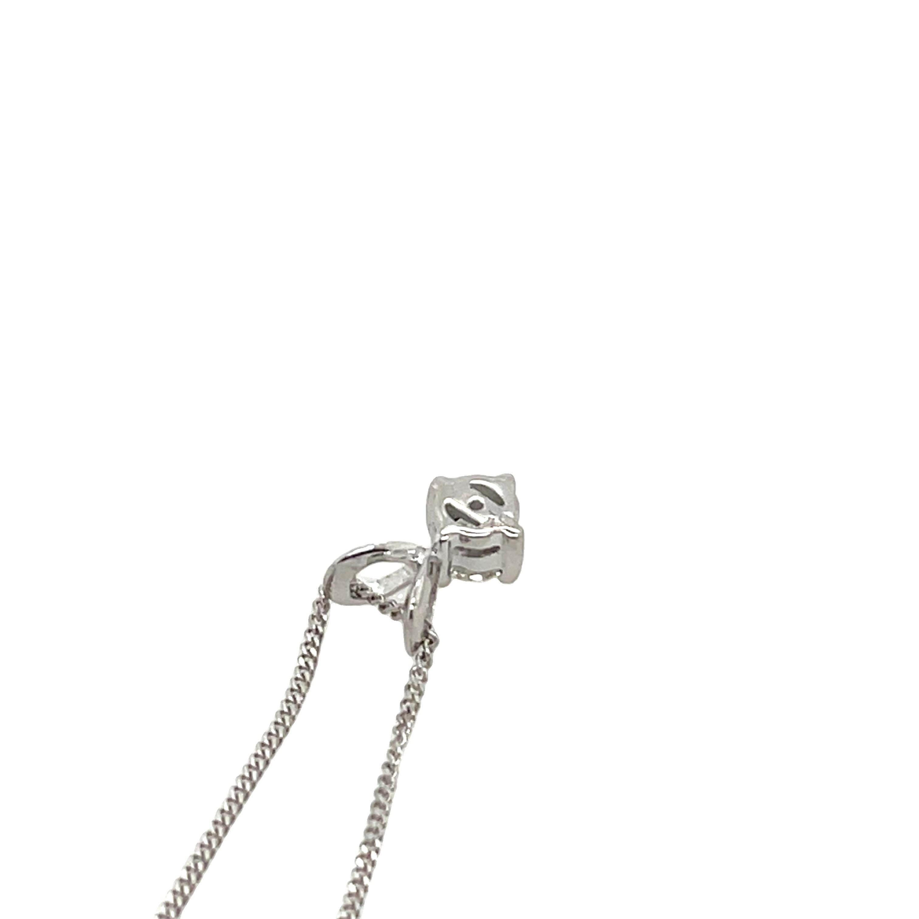 Un pendentif classique en or blanc 9ct mettant en valeur un diamant rond de 0,18ct, gracieusement suspendu à une chaîne de 18 pouces.  Un complément polyvalent et élégant à toute collection de bijoux.

Poids total des diamants : 0,18 ct
Couleur du