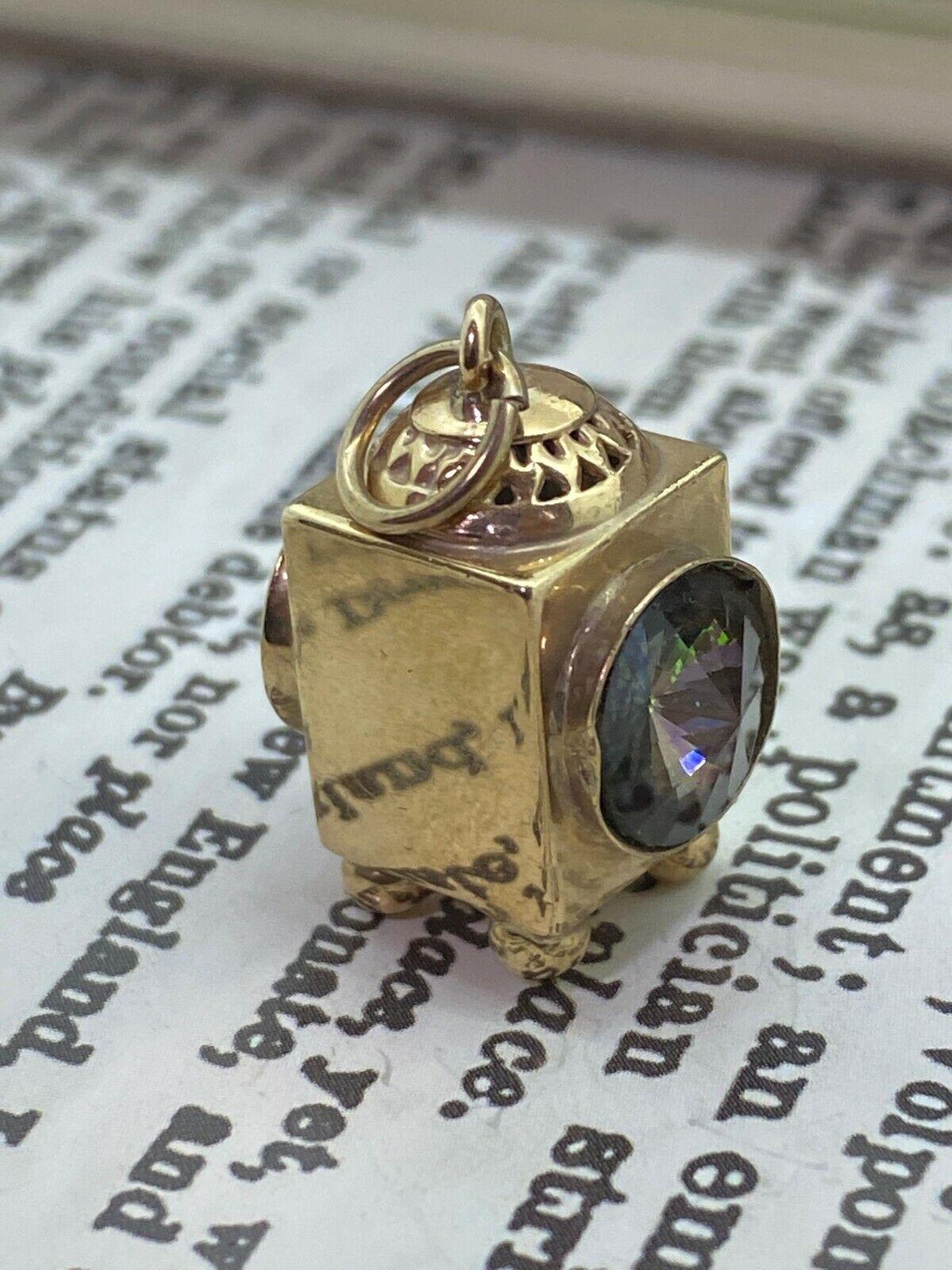 Intricately designed as a Old Lantern 
Set with a smoky quartz from each side - creating an illusion of beaming light from inside 
& finely detailed at the top 

This exquisite charm is crafted in 9K yellow gold, 
bearing English hallmarks (crown &