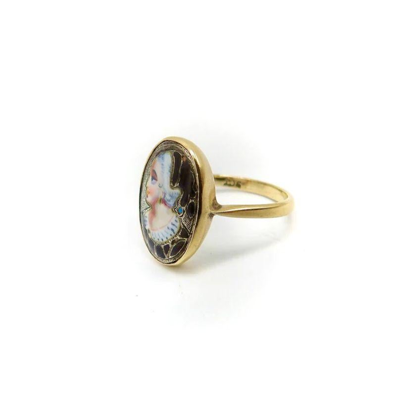 A lovely antique 9 karat gold English ring featuring an enamel miniature portrait painting of a young girl. The portrait in profile is painted on a silver medallion, which has some hand etched stippling work that contrasts nicely with the bold black