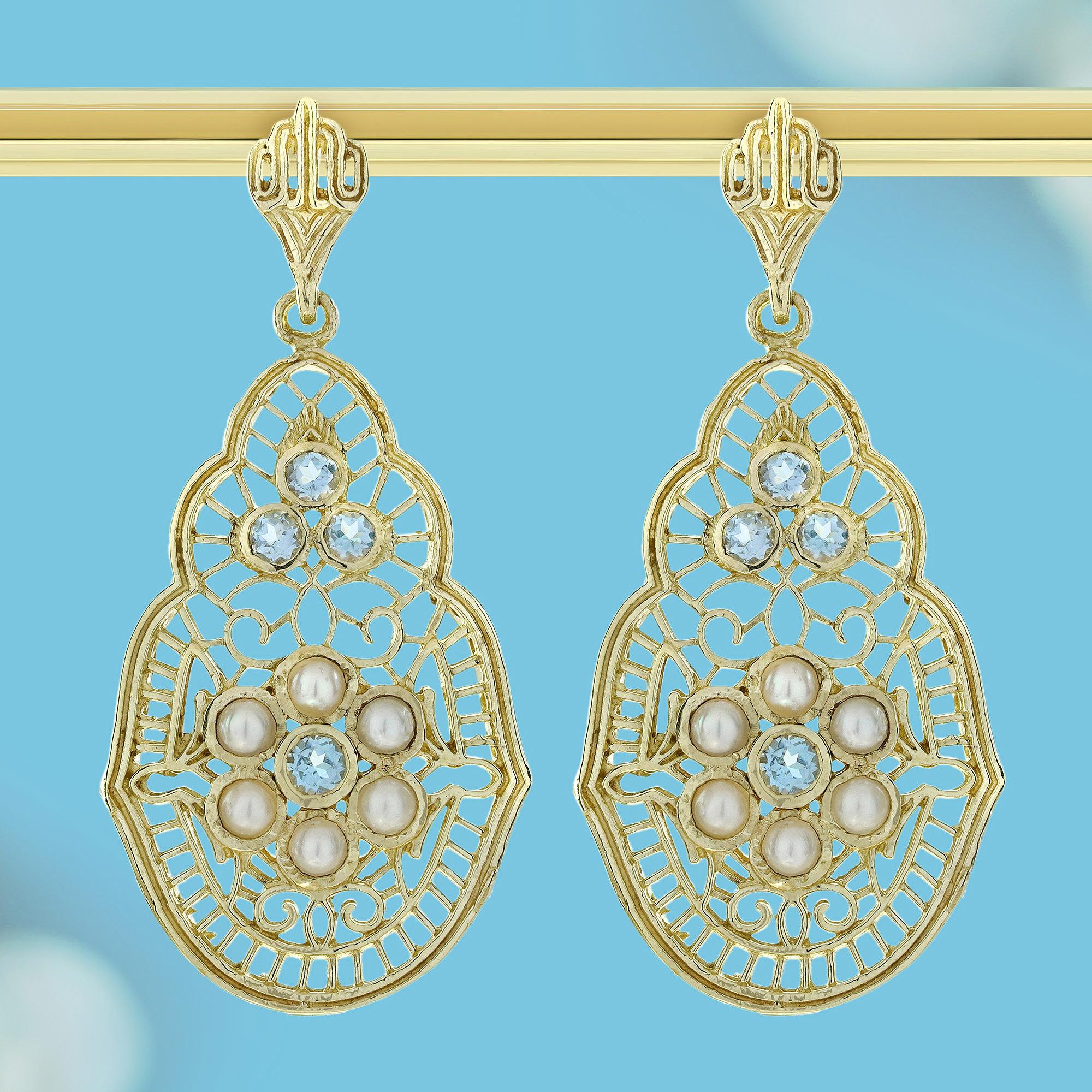 Añade un toque de serena elegancia con estos Pendientes Colgantes de Filigrana Estilo Vintage de Topacio Azul Natural y Perla. Con brillantes gemas de topacio azul combinadas con lustrosas perlas, estos pendientes se balancean con gracia para captar