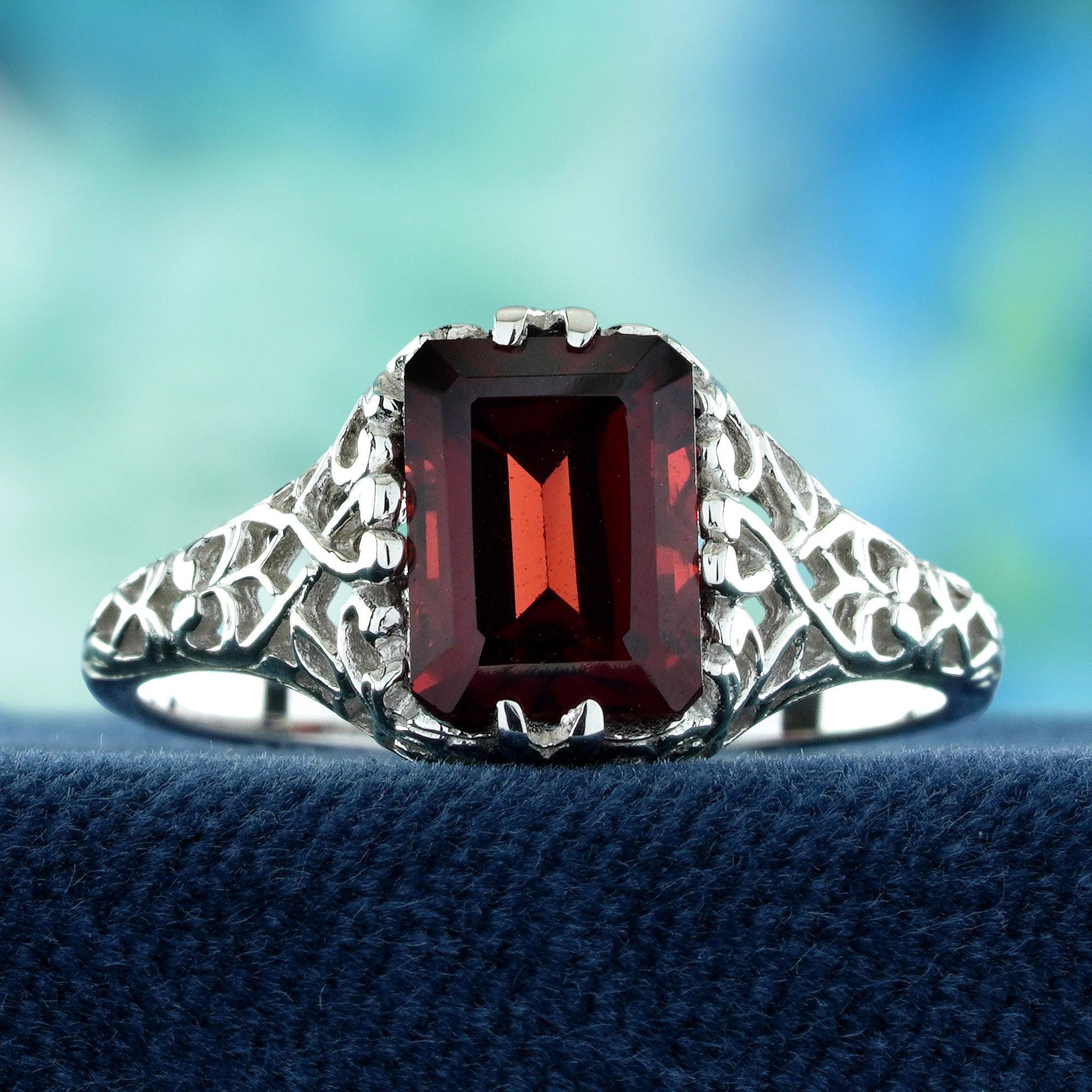 Brings classic elegance to your jewelry collection. 
At its center lies an emerald cut deep red garnet, glowing with rich, romantic warmth that symbolizes passion and strength. The vintage-inspired filigree setting features intricate detailing that