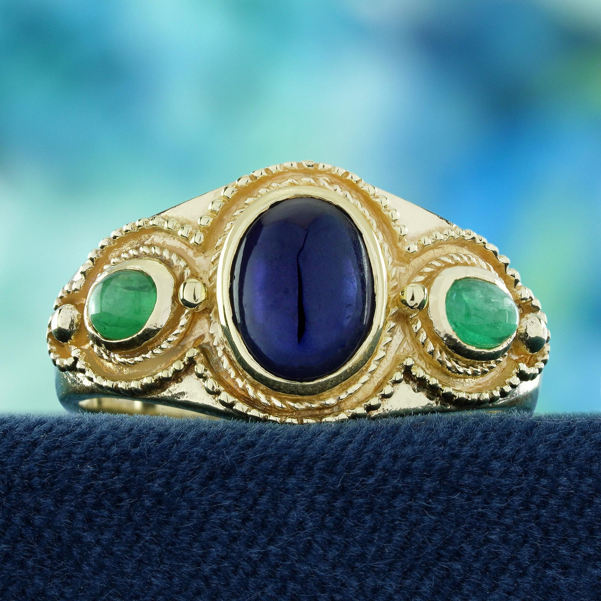 Celebra un'eleganza senza tempo con questo anello a tre pietre con zaffiro naturale e smeraldo cabochon in stile vintage. Uno zaffiro liscio di colore blu intenso è al centro della scena, splendidamente affiancato su entrambi i lati da cabochon di