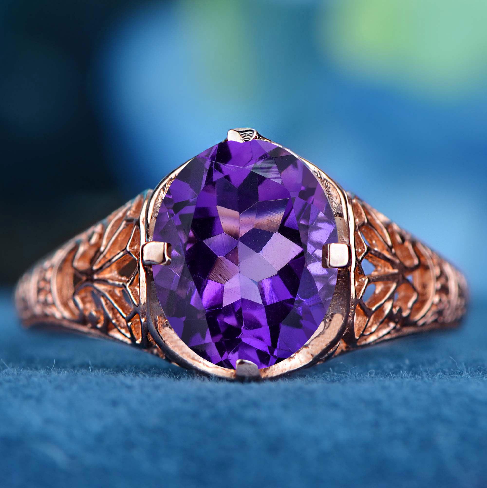 Im Mittelpunkt steht ein wunderschöner Amethyst im Ovalschliff, der satte violette Farbtöne ausstrahlt. Der Edelstein ist in einer klassischen Zackenfassung gefasst und wird durch filigrane Details entlang der Schultern ergänzt, die dem Schmuckstück