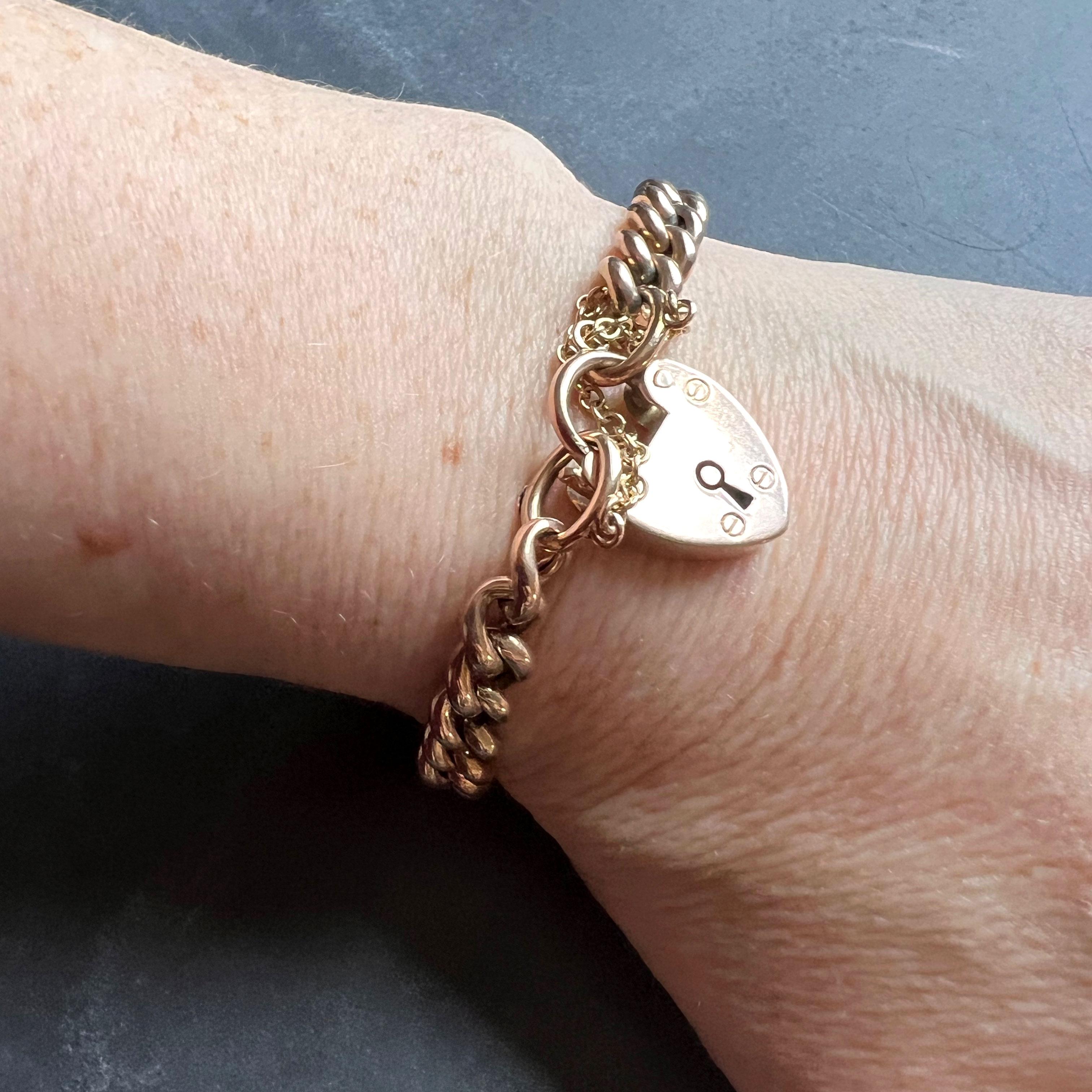 A 9 karat (9K) rose gold curb link bracelet with heart padlock clasp. The bracelet stamped 9C in a cartouche for 9 karat gold, the heart marked for P&M Ltd (unknown makers), Birmingham, 9 karat gold. 7” long.

Dimensions: 18 x 0.7 x 0.3cm
Heart