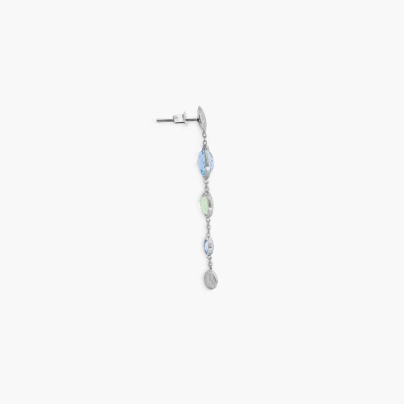 9K satin white gold Kensington long drop earrings with topaz and green amethyst

This pair of 9K white gold earrings have been handset with gradating sizes of blue topaz and green amethyst stones by our artisans into this long drop style. As the