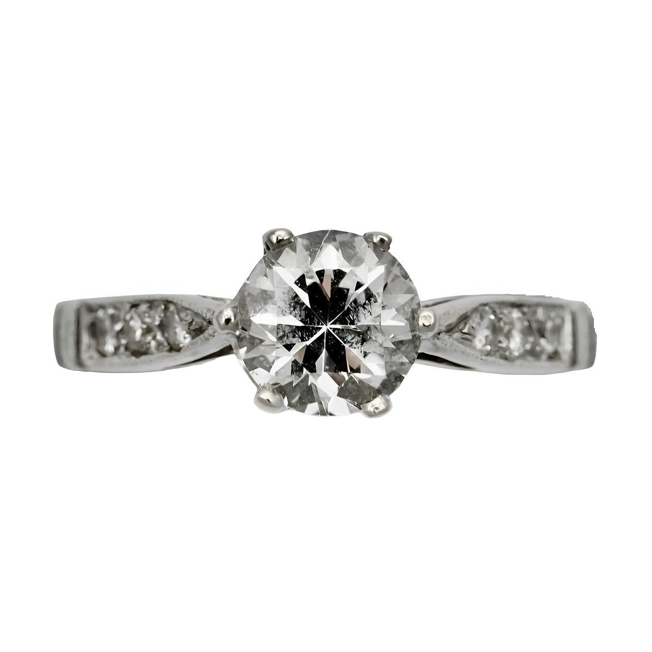 Beautiful 9K white gold ring, featuring a faceted solitaire crystal, with six diamonds decorating the shoulders. 

The ring is stamped with a crown, 375, a leopard's head, and the letter E. The makers mark is BL. This means that the ring is 9K gold,