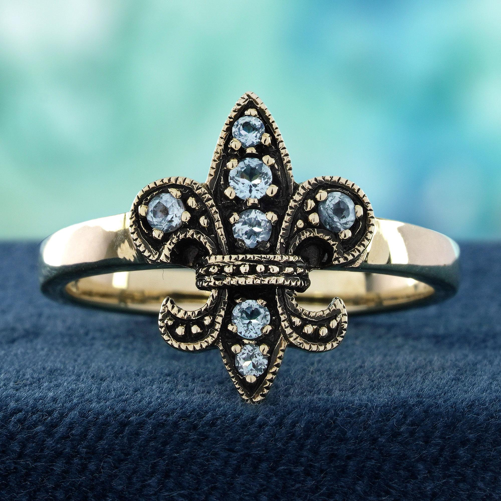Inspired by royal elegance, this vintage-style ring showcases a luminous blue topaz at its heart, glowing with the clarity of a clear sky. Intricately designed with a Fleur De Lis motif, it evokes timeless grace and noble charm. The delicate curves
