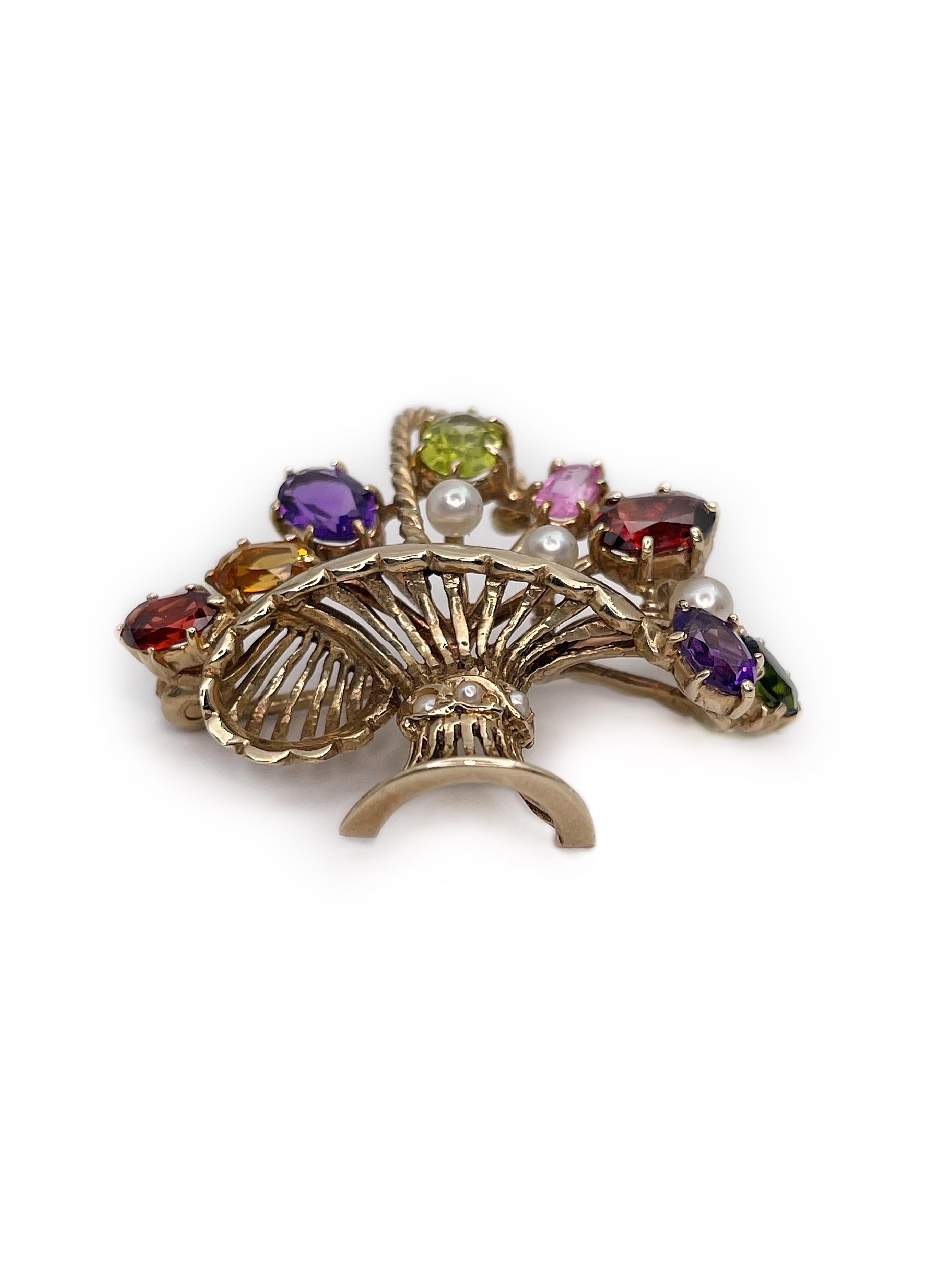 This is a playful flower basket brooch crafted in 9K gold. 

The piece features two peridots, two amethysts, two red garnets, one rhodolite and one citrine. It is adorned with seven cultured pearls. 

The brooch has a safe clasp. 

Weight: