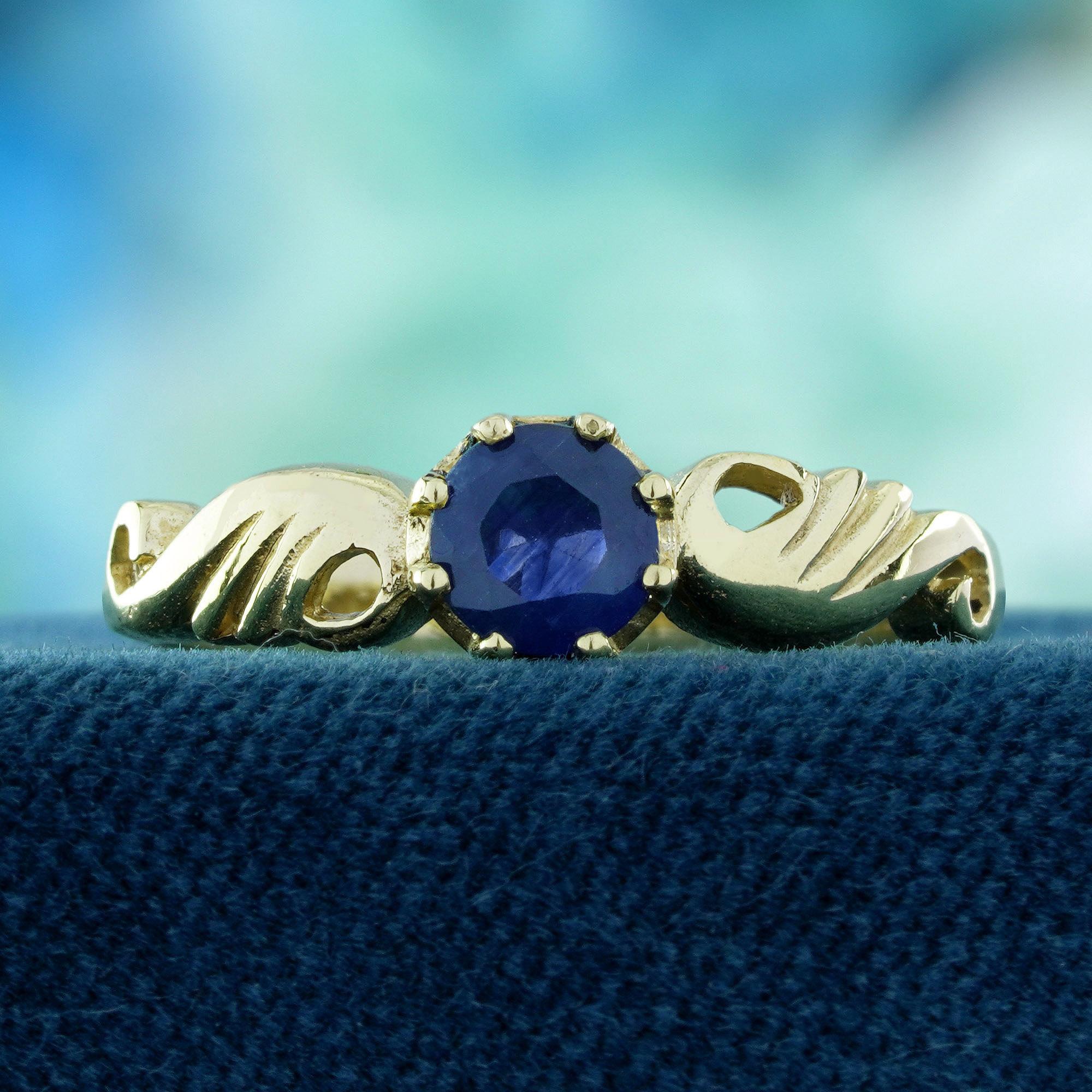 Ein brillanter, runder Saphir steht im Mittelpunkt, sicher gefasst in einer zarten Zackenfassung, die sein tiefes, bezauberndes Blau hervorhebt. Die Schultern sind mit anmutigen floralen Kurvendetails am Schaft versehen, die dem Design einen