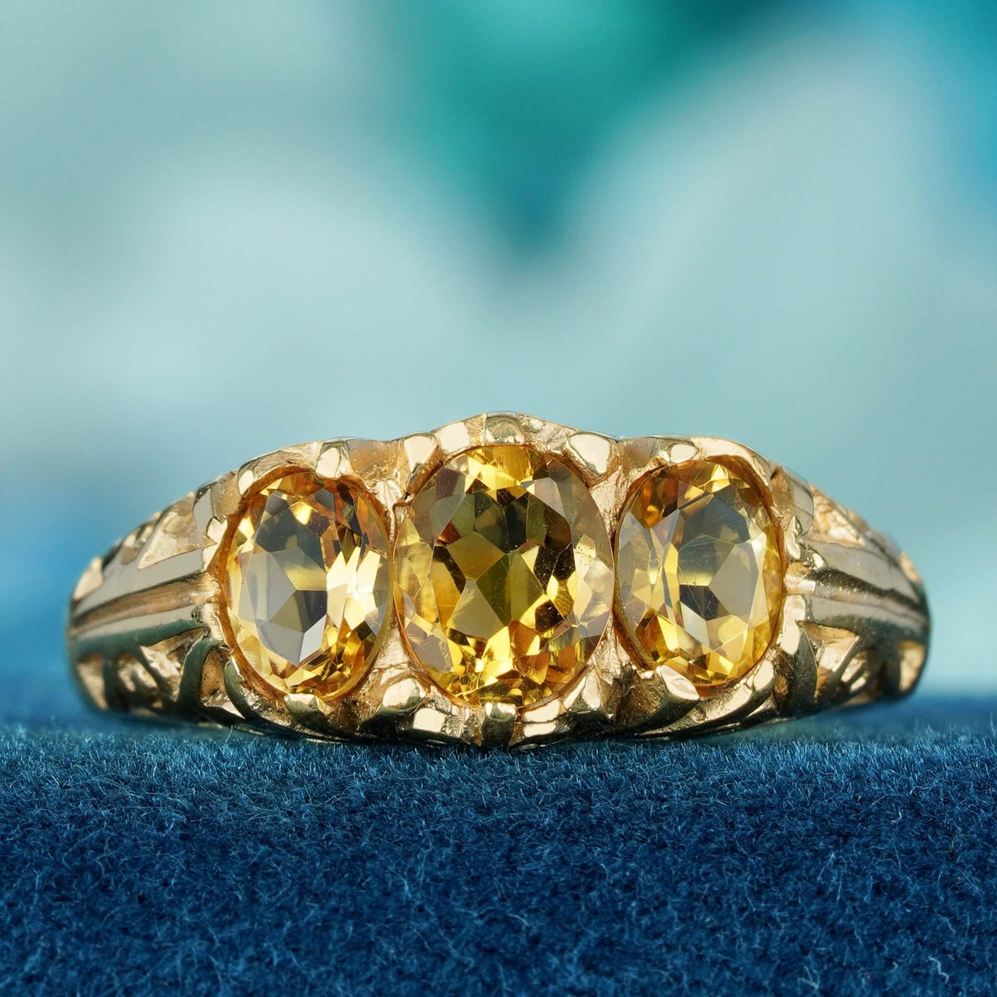 La bague à trois pierres est ornée d'une citrine naturelle chaude et rayonnante, qui brille de ses reflets dorés. Flanqué de deux pierres complémentaires plus petites, le design équilibre l'élégance et l'harmonie. Les détails complexes de la bande