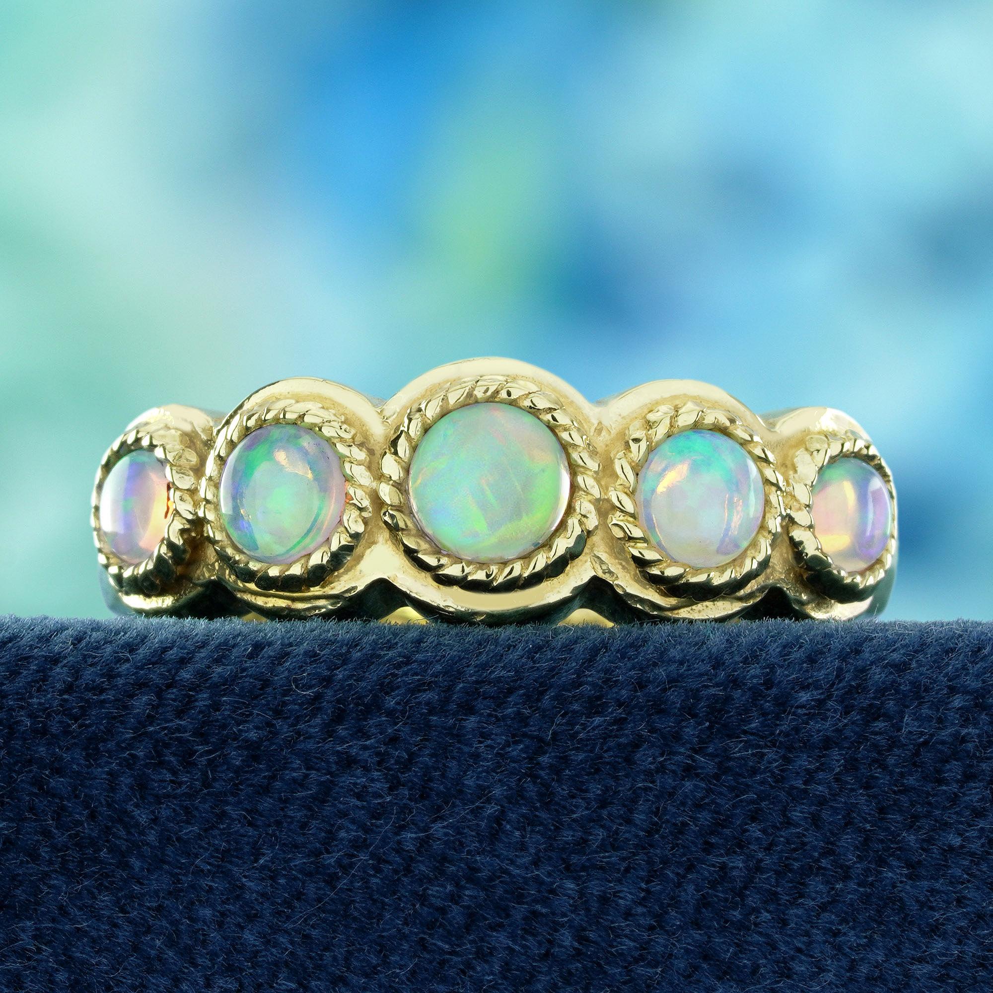 This vintage-style five-stone band ring showcases five shimmering natural opals, each glowing with a unique play of colors. The stones are gracefully set in a classic design that highlights their ethereal beauty. Intricate detailing on the band adds
