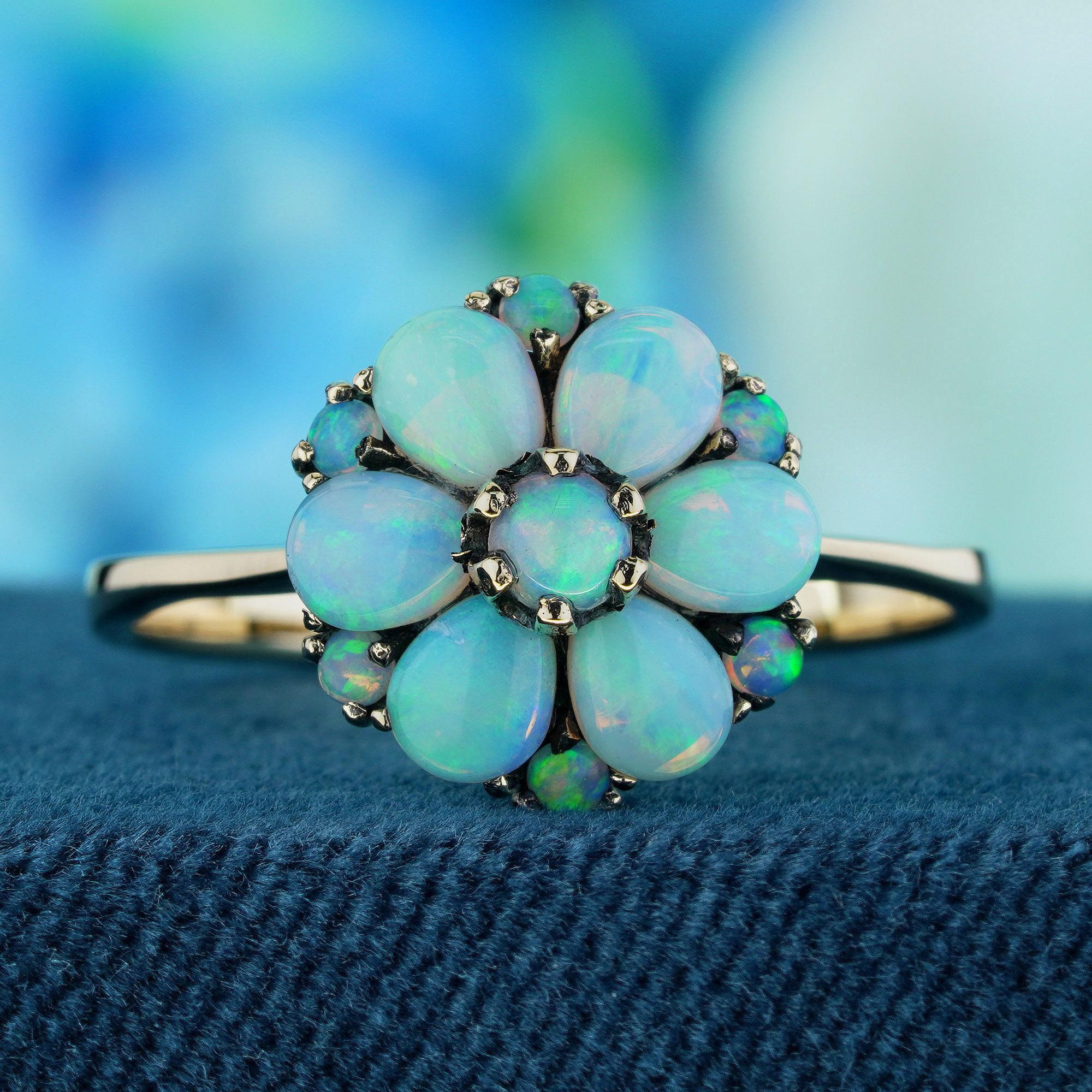 A luminous opal at the center, set in delicate prongs to let its natural glow shine through. Surrounding the opal, a cluster of floral-inspired details enhances the ring’s vintage charm with soft, romantic appeal. The play of colors within the opal