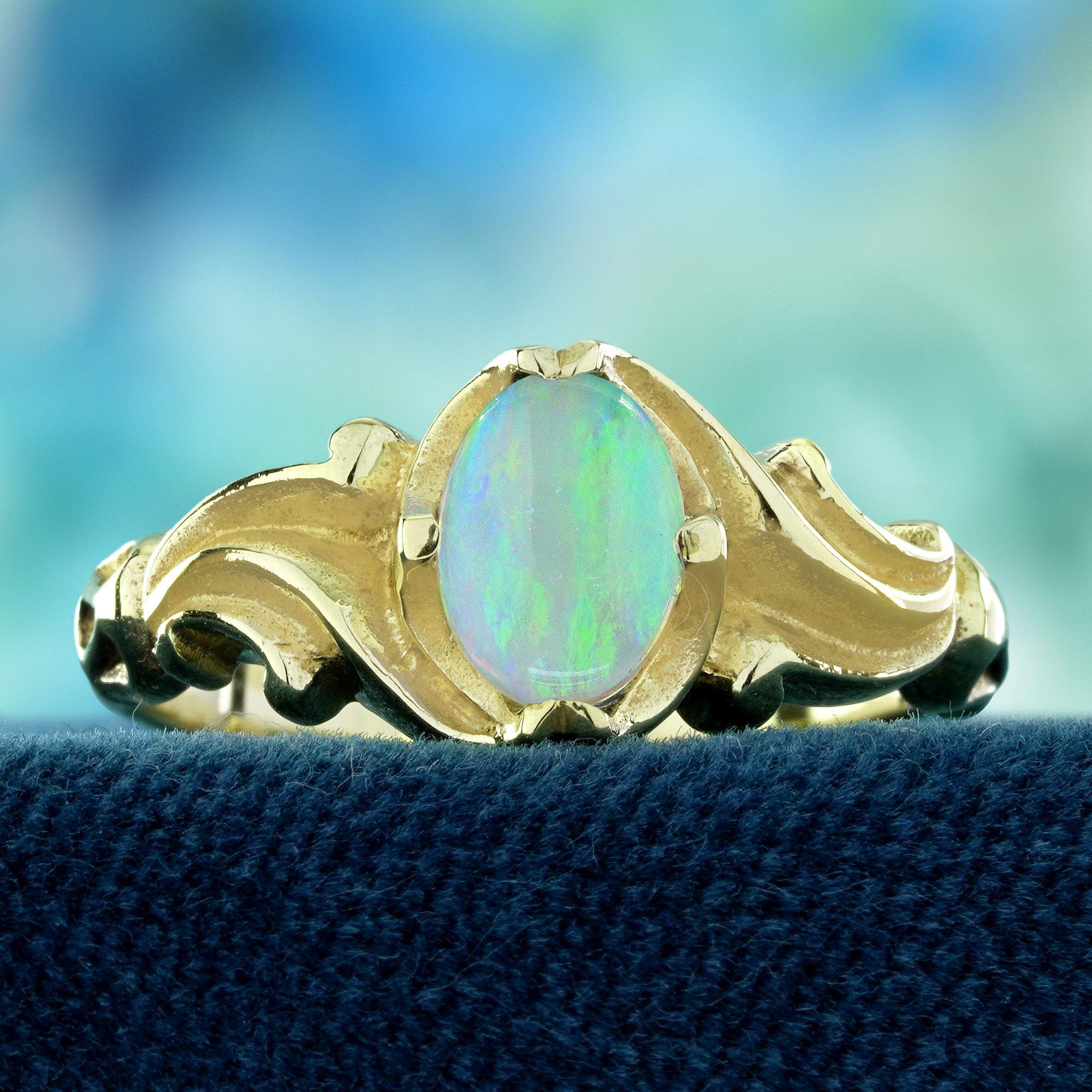 Au centre, une opale ovale lumineuse brille de couleurs douces et irisées qui se transforment magnifiquement à la lumière. L'opale est entourée d'un délicat motif en grappe qui rehausse son charme éthéré et son attrait vintage. Façonnée avec des
