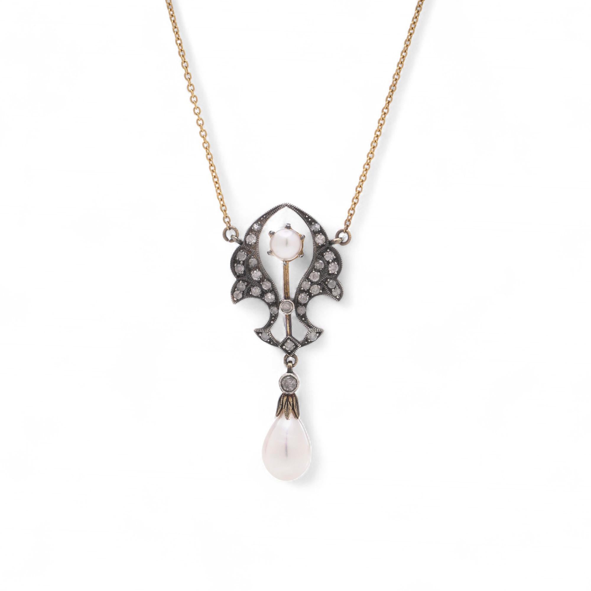 Una delicata collana in oro e argento 9kt con un pendente a forma di goccia con diamanti e perle. Il design presenta 28 diamanti rotondi taglio brillante incastonati lungo il pendente, completati da una lucente perla rotonda e da una perla allungata