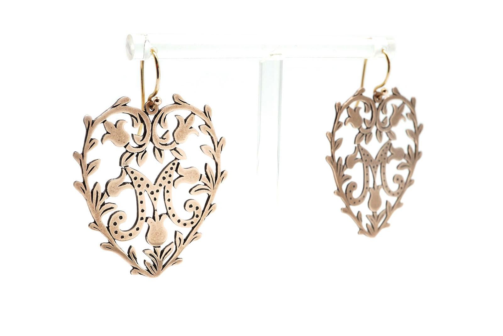 Earrings forged with rue leaves heart shaped decoration enclosing the M monogram.
These sophisticated and delicate earrings represent the fusion of the sacred with the profane by the use of the Marian symbol and the Rue leaves considered by the