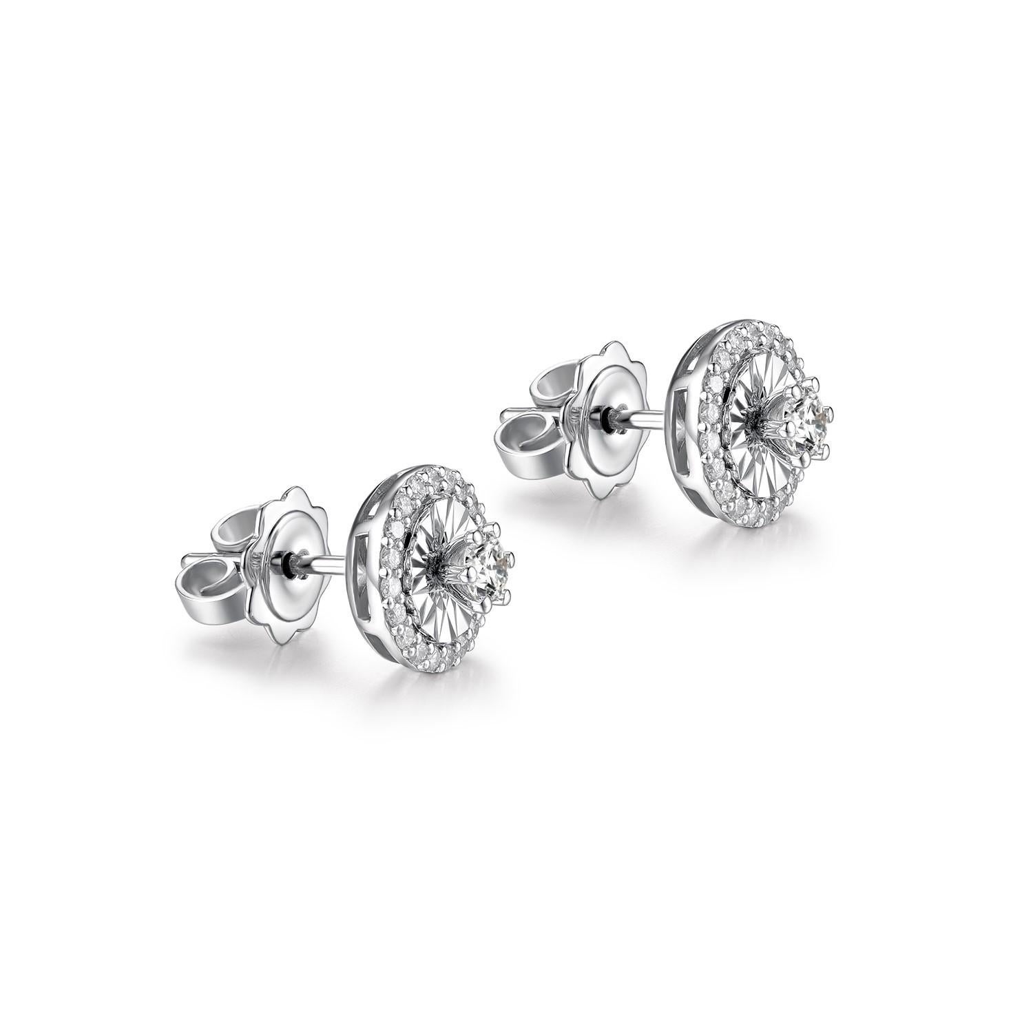 These diamond stud earrings are a classic piece of fine jewelry, featuring a central round-cut diamond encircled by a halo of smaller diamonds, set in 14K white gold. The main diamonds are prong-set, enhancing their natural brilliance. The