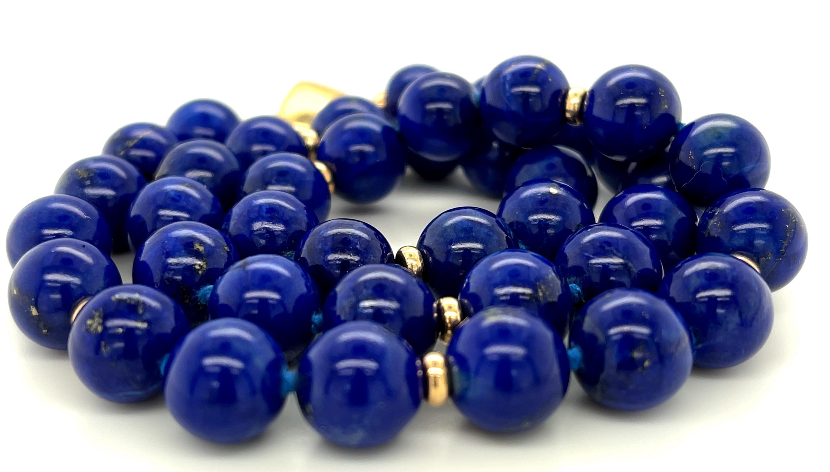 Ce joli cordon de perles de lapis présente des perles rondes de 9 mm de diamètre joliment assorties et d'une riche couleur bleu royal ! Les perles sont disposées avec des intercalaires en or jaune 14 carats hautement polis qui donnent au collier une