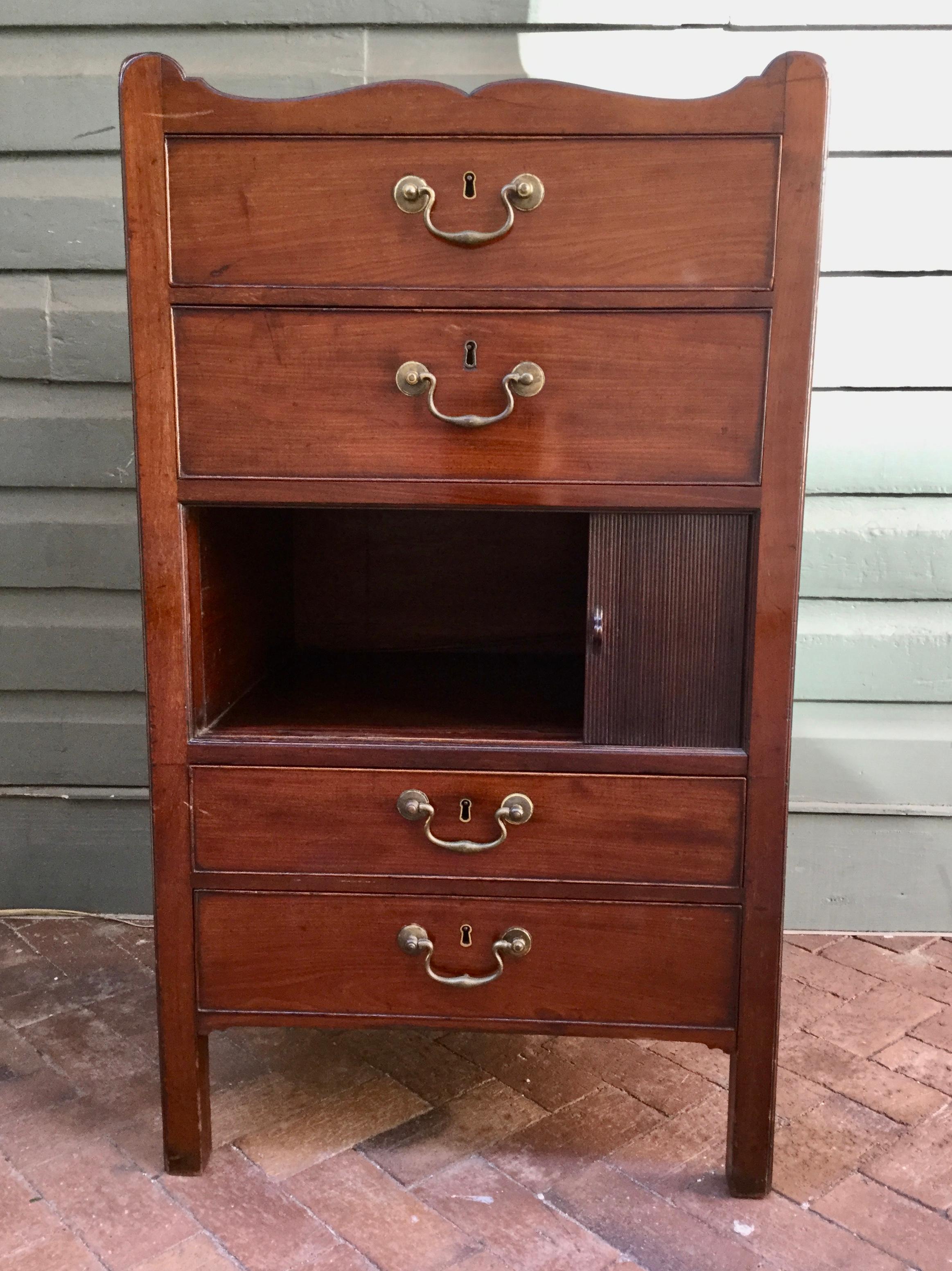 This period English Georgian dressing stand is made out of solid mahogany with oak lined drawers. The dressing commode has two drawers above a tambor cabinet door and two drawers below giving the chest prefect balance. The dressing chest has the