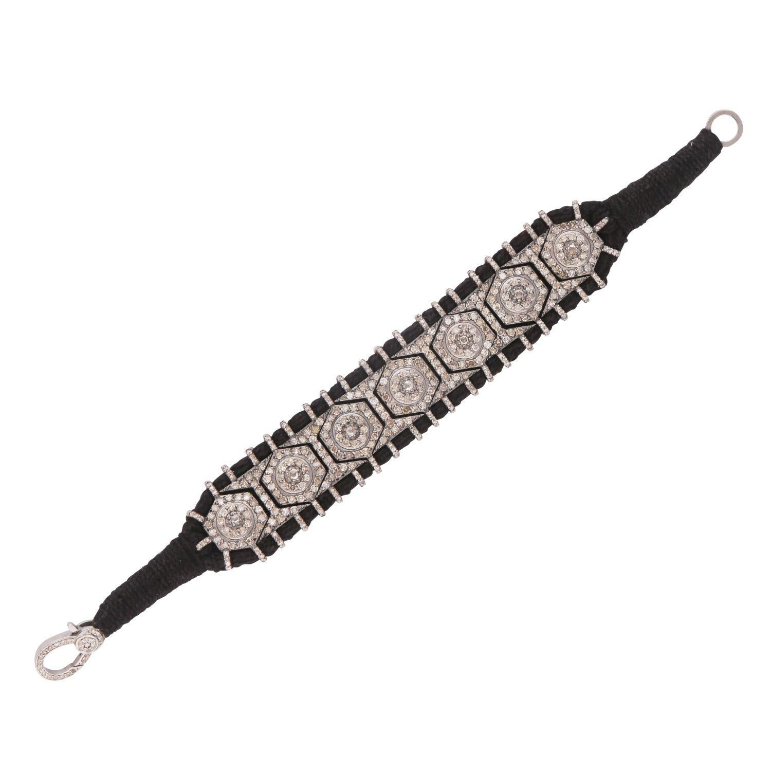 Inspired by the ancient traditional ‘baju’ bracelet from the 9th century, this bracelet is re created with a more contemporary feel.

Set on black cotton and silver, with 6.21 carat of small diamonds and 19.658 grams of silver.

It has a easy clasp